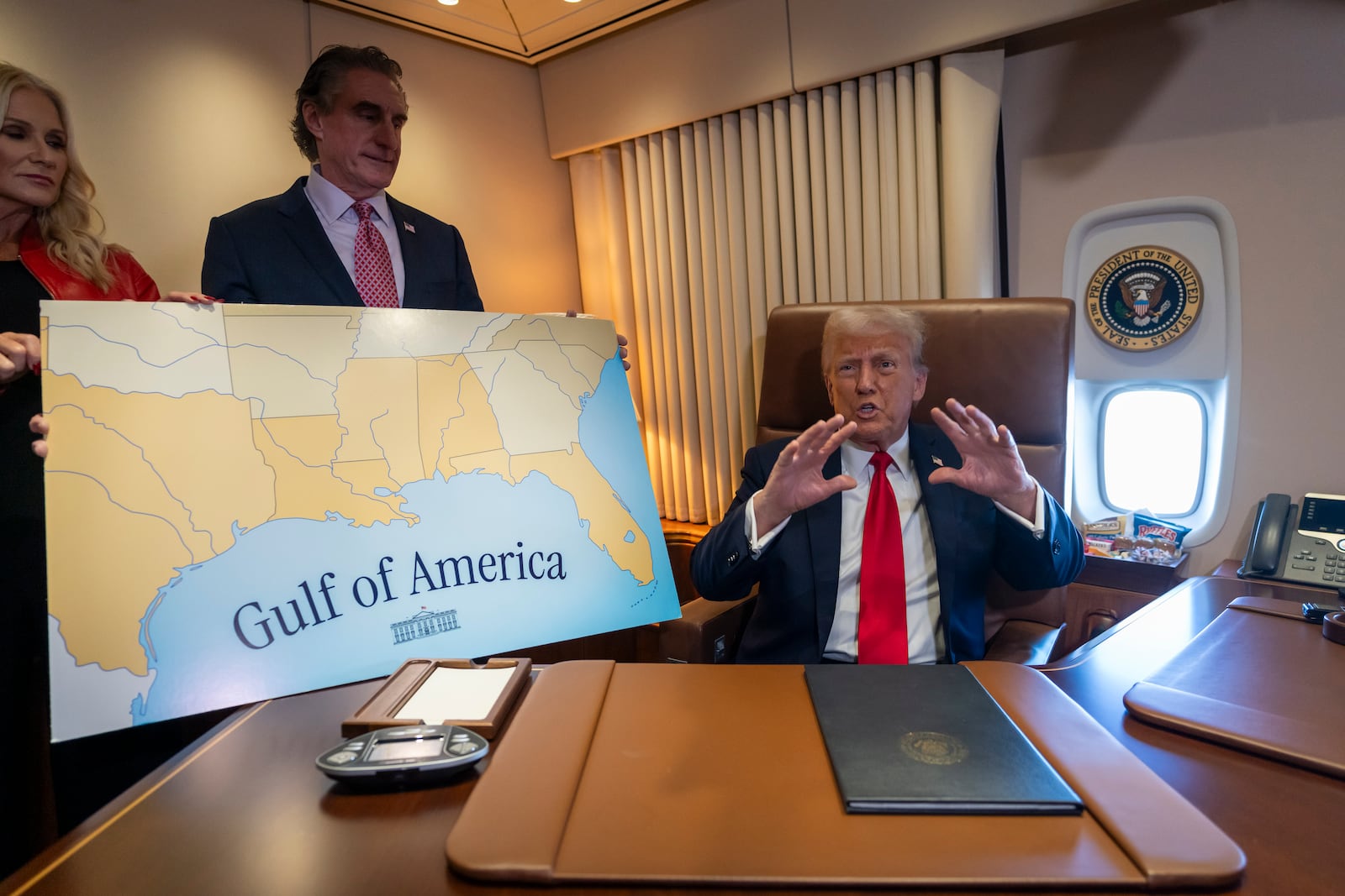 President Donald Trump, from right, speaks to reporters accompanied by Interior Secretary Doug Burgum and Burgum's wife Kathryn Burgum, aboard Air Force One where Trump signed a proclamation declaring Feb. 9 “the first ever Gulf of America Day," as he travels from West Palm Beach, Fla. to New Orleans, Sunday, Feb. 9, 2025. (AP Photo/Ben Curtis)