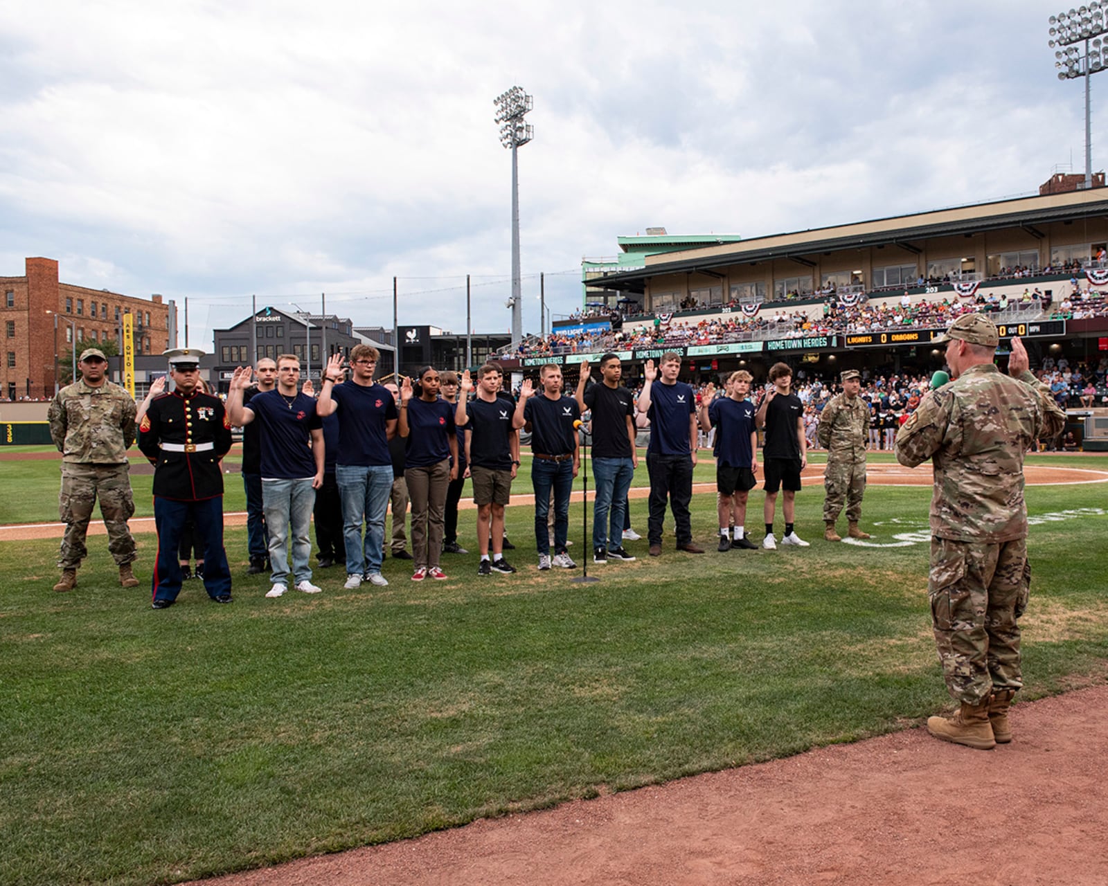 Col. Christopher Meeker, 88th Air Base Wing and Wright-Patterson Air Force Base commander, administers the oath of enlistment to a group of Air Force and Marine recruits in the Delayed Entry Program during a Dayton Dragons game Aug. 13 at Day Air Ballpark. U.S. AIR FORCE PHOTO/JAIMA FOGG