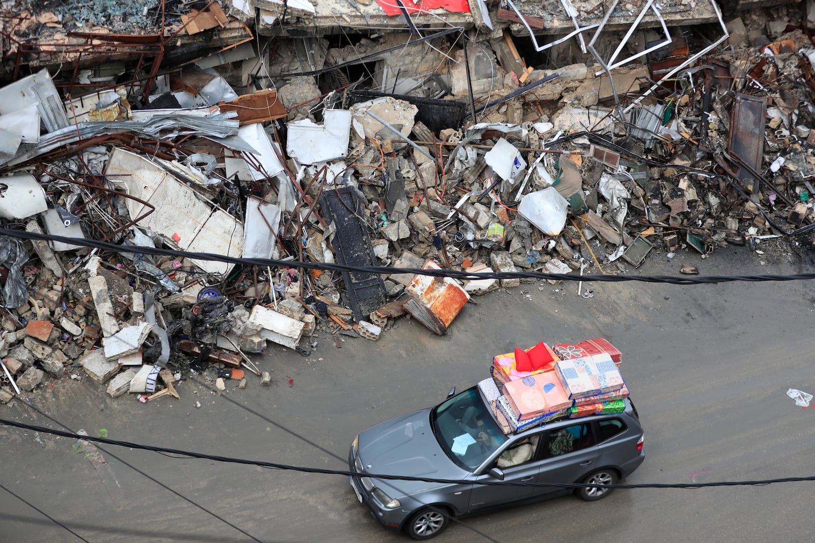 Displaced residents drive past destroyed buildings as they return to Nabatiyeh, Lebanon, after a ceasefire between Israel and Hezbollah went into effect on Wednesday, Nov. 27, 2024. (AP Photo/Mohammed Zaatari)