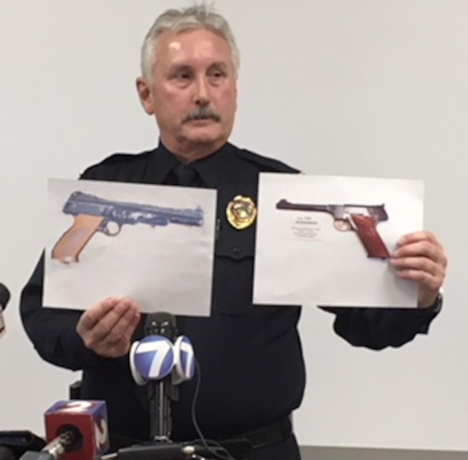 Police Chief Ron Hess shows two pictures during Thursday's press conference on the fatal officer-involved shooting. To the left is the pellet gun recovered on the scene and to the right is a similar-in-style handgun. CHUCK HAMLIN / STAFF