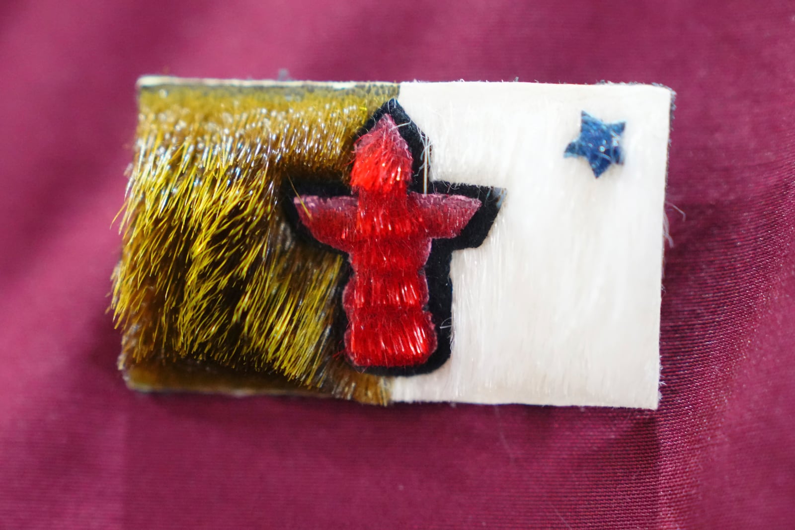 A seal skin pin of the Nunavut flag worn by Nunavut Premier P.J. Akeeagok is shown at an announcement at a Canadian Armed Forces forward-operating location in Iqaluit, Nunavut, Tuesday, March 18, 2025. (Sean Kilpatrick/The Canadian Press via AP)