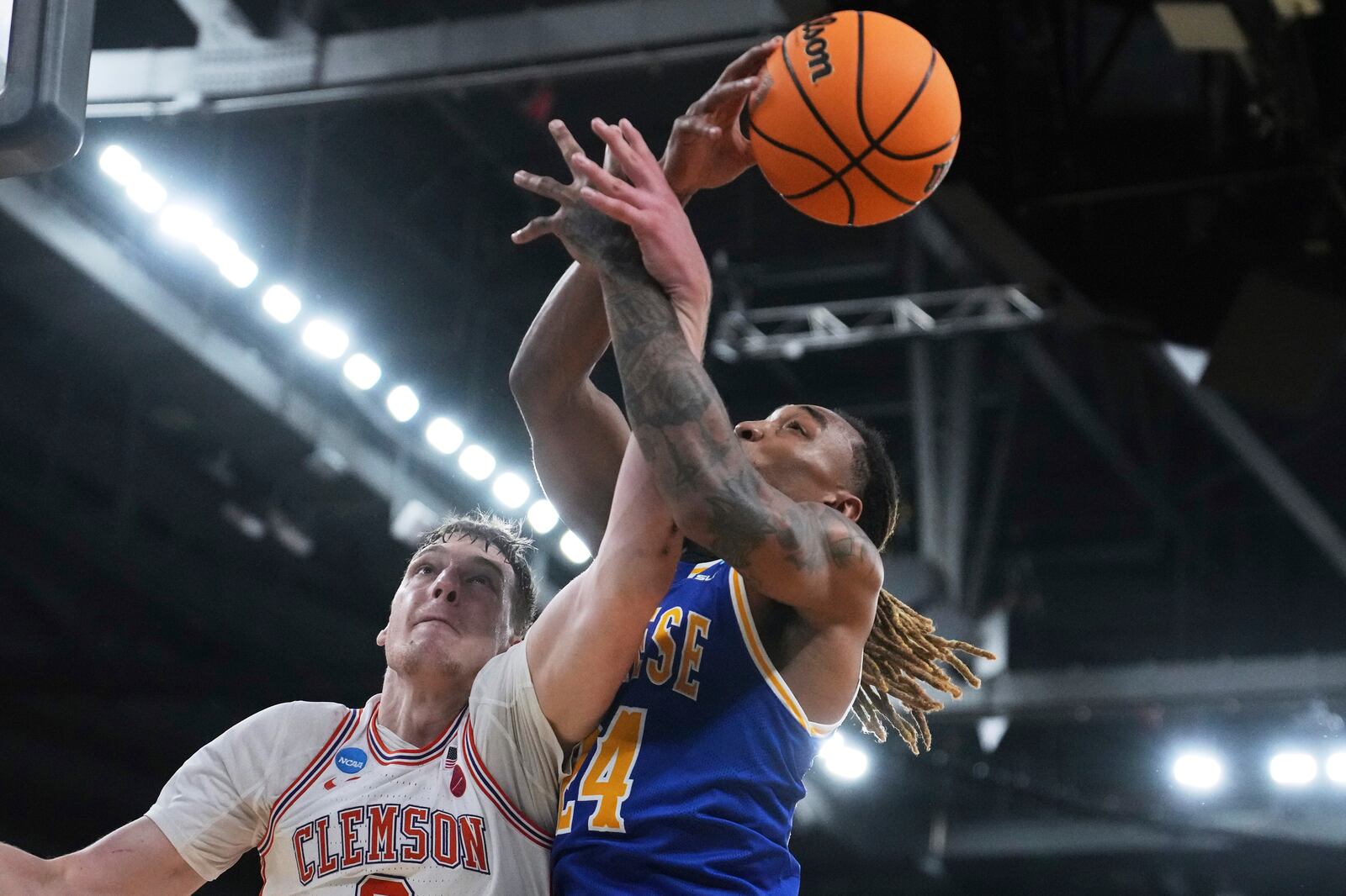 McNeese State forward Christian Shumate (24) battles Clemson center Viktor Lakhin, left, for a rebound during the first half in the first round of the NCAA college basketball tournament, Thursday, March 20, 2025, in Providence, R.I. (AP Photo/Charles Krupa)