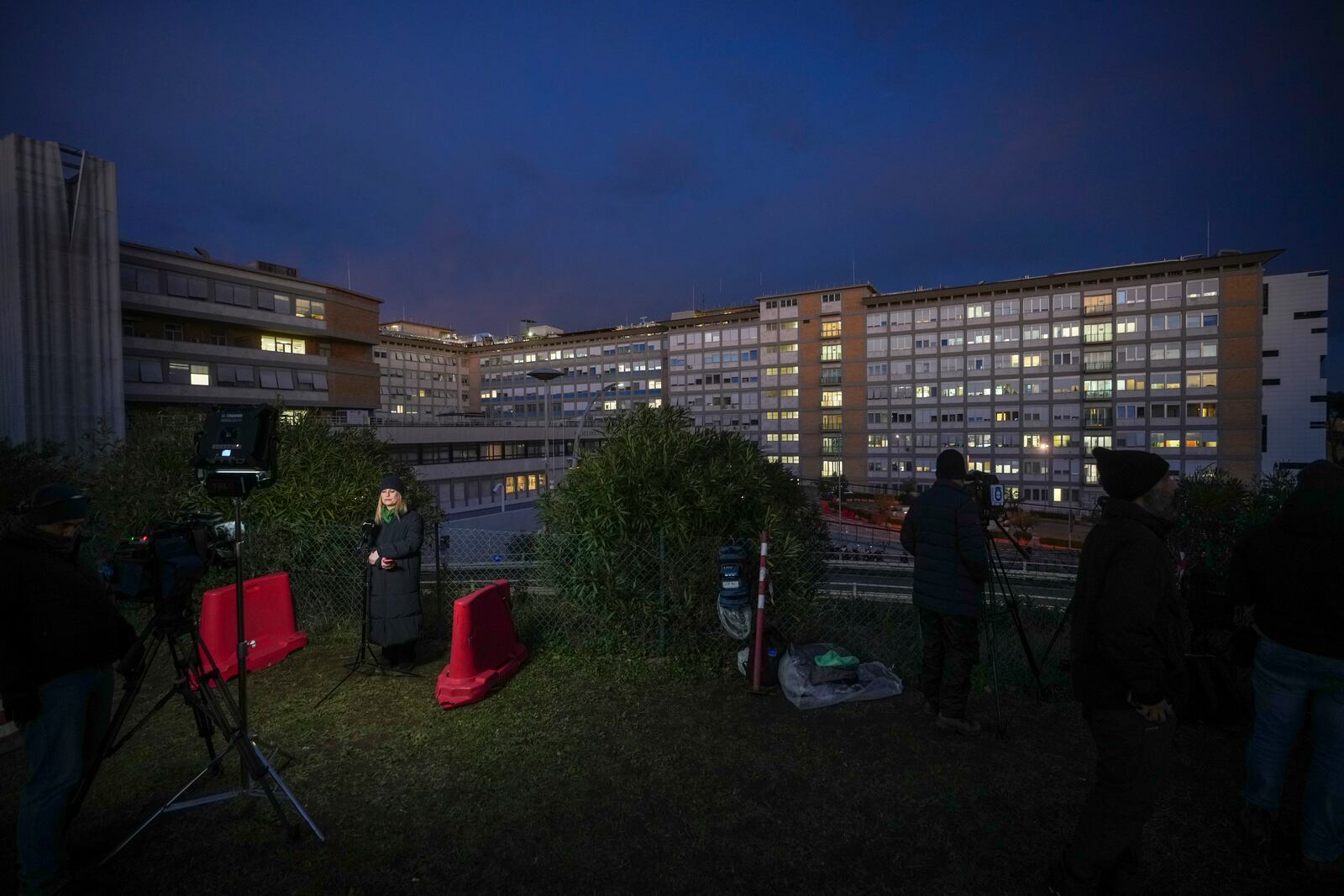 Journalists wait outside the Agostino Gemelli Polyclinic in Rome, Saturday, Feb. 15, 2025, where Pope Francis was hospitalized Friday after a weeklong bout of bronchitis worsened and is receiving drug therapy for a respiratory tract infection. (AP Photo/Alessandra Tarantino)