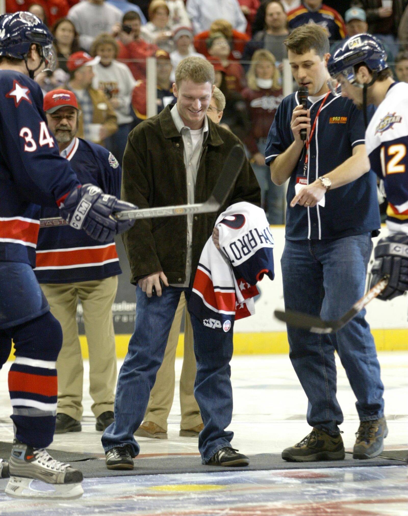 Dale Earnhardt Jr, standing on center ice, is about to drop the puck prior to the Dayton Bombers game in 2004.  Earnhardt was driven onto the ice in a white limo.