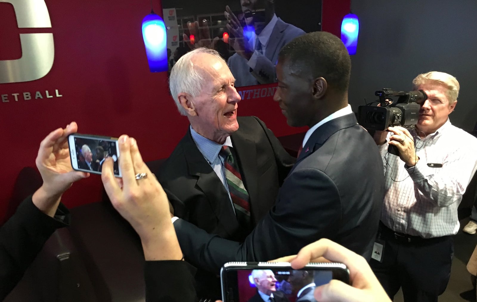 Dayton’s Don Donoher hugs new basketball coach Anthony Grant after Grant’s introductory press conference on Saturday, April 1, 2017, at UD Arena. David Jablonski/Staff