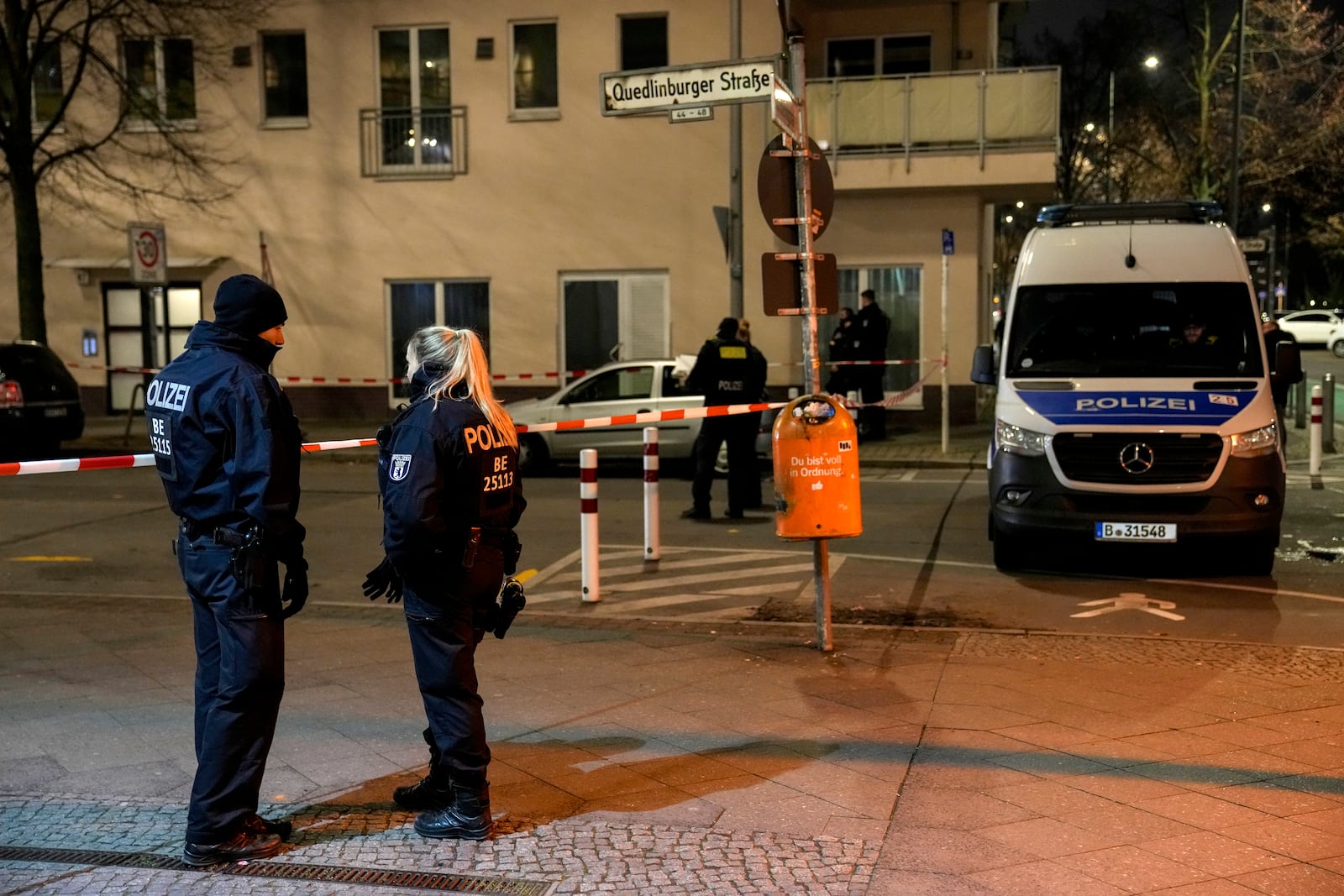 Police officers stand guard in front of a Rewe Market after a knife attack, in Berlin, Germany, Tuesday, Dec. 31, 2024. (AP Photo/Ebrahim Noroozi)