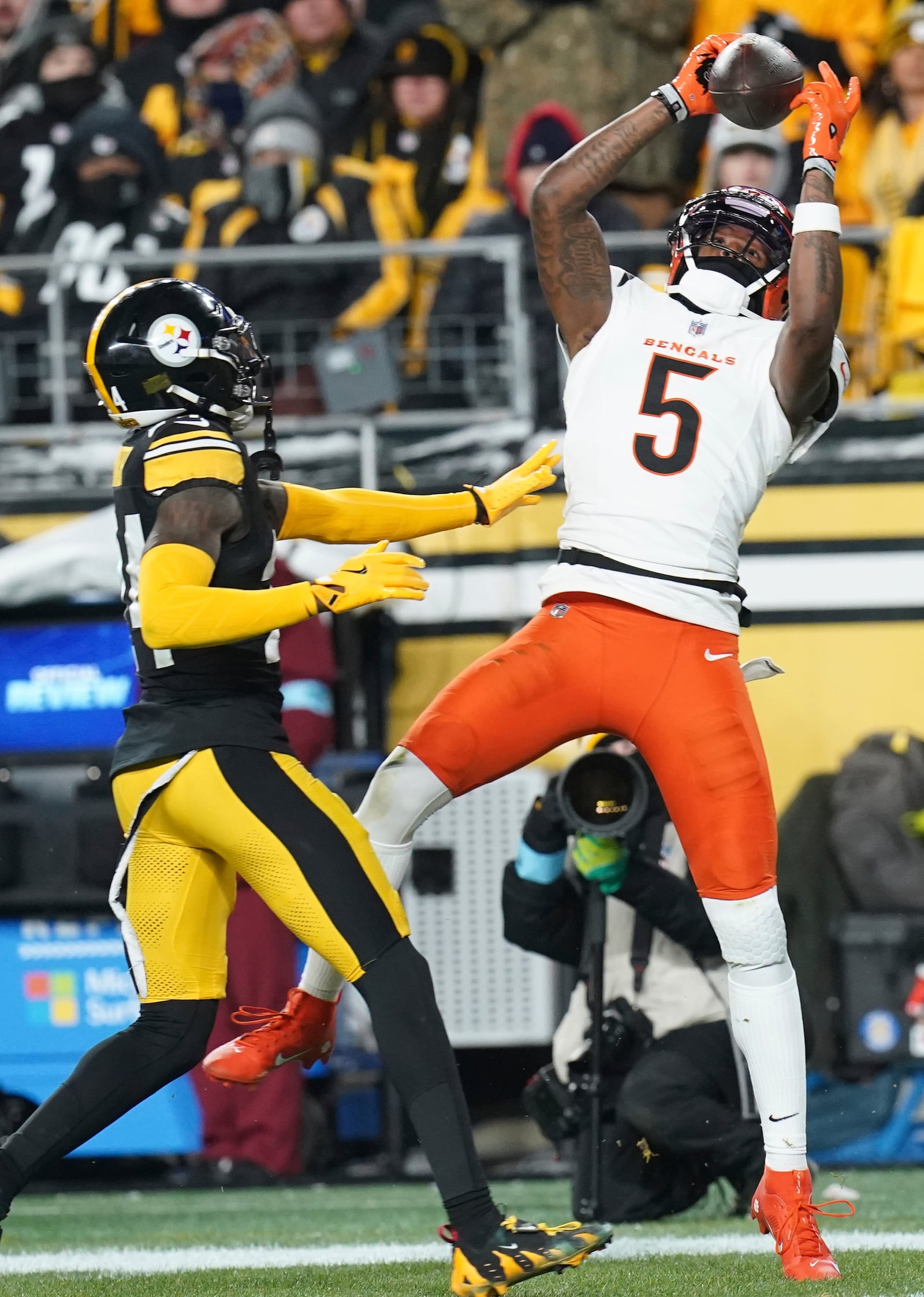 Cincinnati Bengals wide receiver Tee Higgins (5) catches a pass in front of Pittsburgh Steelers cornerback Joey Porter Jr. (24) during the first half of an NFL football game in Pittsburgh, Saturday, Jan. 4, 2025. (AP Photo/Matt Freed)