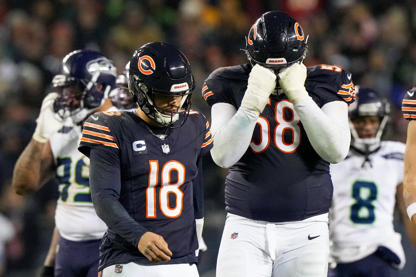 Chicago Bears quarterback Caleb Williams (18) and offensive tackle Darnell Wright (58) react while walking off the field during the second half of an NFL football game against the Seattle Seahawks, Thursday, Dec. 26, 2024, in Chicago. The Seahawks won 6-3. (AP Photo/Nam Y. Huh)