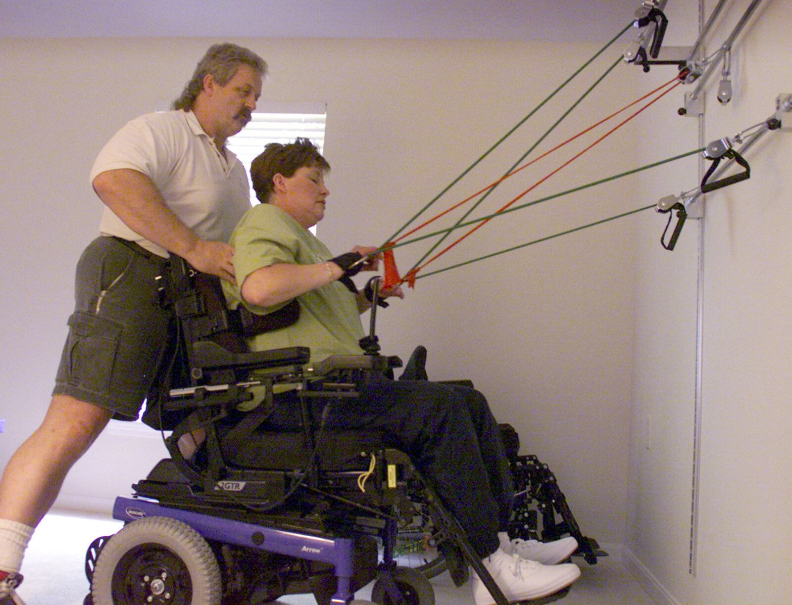 Personal trainer Joe MacGowan works with Mary Beall at her home three days a week.  She uses an exercise sytem made up of a wall mounted unit and surgical rubber tubing strips. This was photographed on August of 2001.