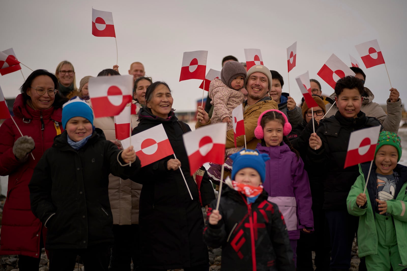 People wave Greenland flags during an event organized by Qupanuk Olsen, Greenland's most popular social media influencer and a candidate for the Naleraq party in the next March 11 election, in Nuuk, Greenland, Sunday, Feb. 16, 2025. (AP Photo/Emilio Morenatti)