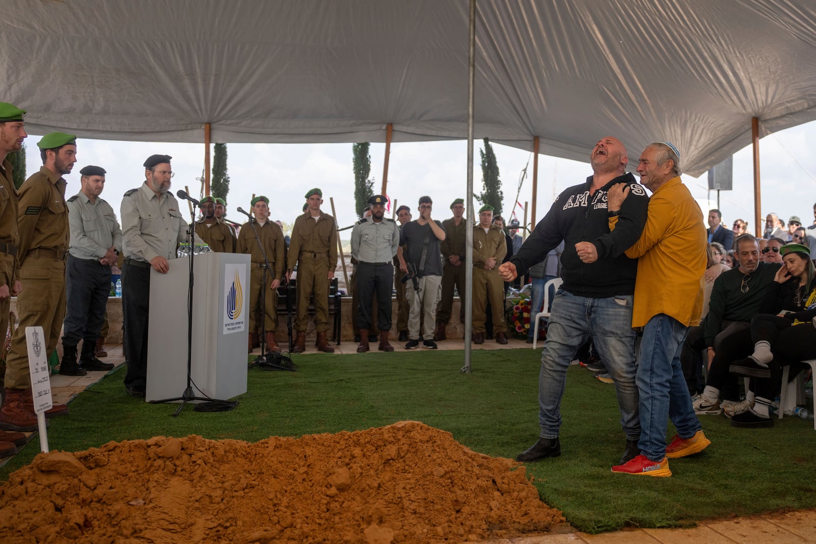 Nir, father of Israeli soldier Sergeant Yahav Maayan who was killed in combat in the Gaza Strip, reacts next to his son's grave during his funeral at a military cemetery in Modiin, Israel, Sunday, Jan. 12, 2025. (AP Photo/Ohad Zwigenberg)