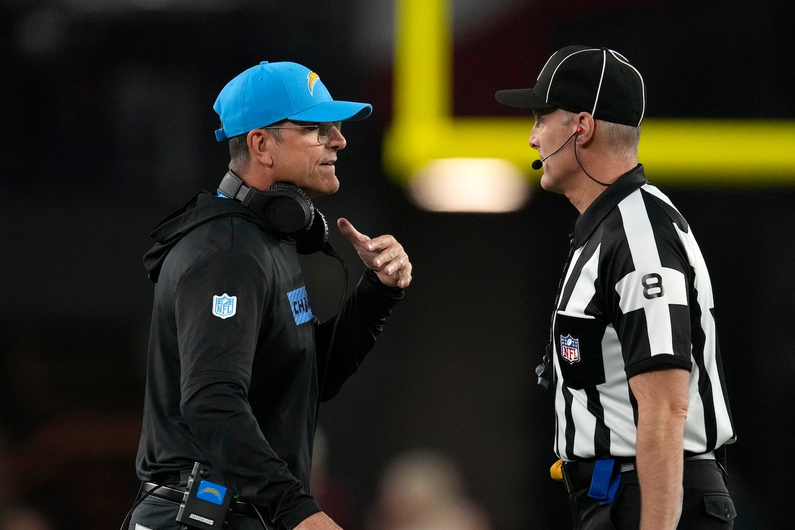 Los Angeles Chargers head coach Jim Harbaugh, left, talks with down judge Dana McKenzie, right, during the first half of an NFL football game against the Arizona Cardinals, Monday, Oct. 21, 2024, in Glendale Ariz. (AP Photo/Matt York)