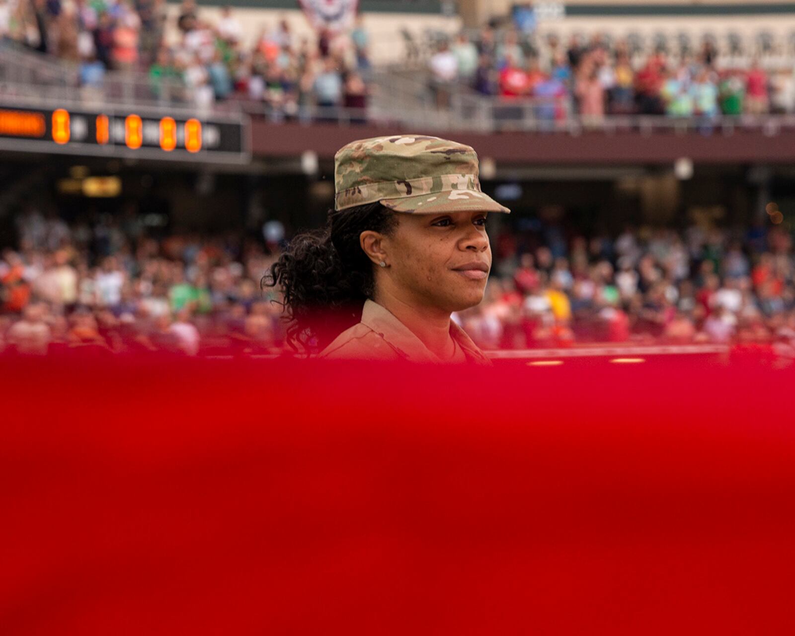 Master Sgt. Bakiden Gordon helps display a large American flag during American Celebration night Aug. 13 at Day Air Ballpark. Gordon is assigned to the 445th Airlift Wing at Wright-Patterson Air Force Base. U.S. AIR FORCE PHOTO/JAIMA FOGG