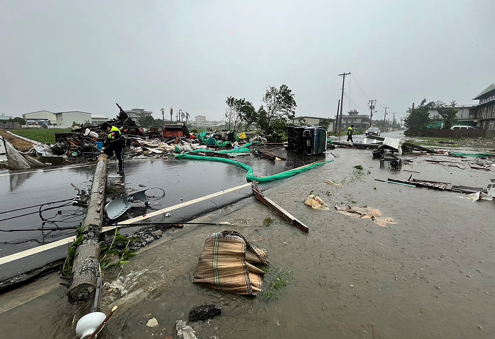 In this photo released by Hualien County Fire Department, police check an area destroyed by the wind from Typhoon Kong-rey in Hualien County, eastern Taiwan, Thursday, Oct. 31, 2024. (Hualien County Fire Department via AP)