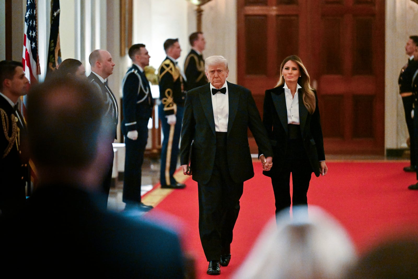 President Donald Trump and first lady Melania Trump arrive at the National Governors Association dinner and reception in the East Room of the White House Saturday, Feb. 22, 2025, in Washington. (Pool via AP)