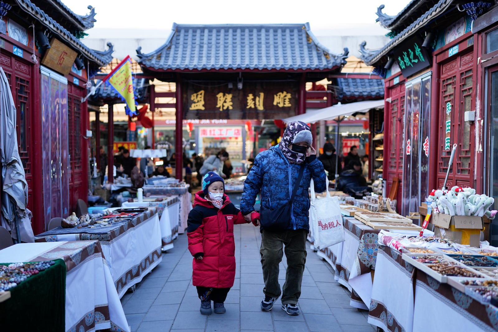 A boy and a woman shop at a market in Beijing, Thursday, Jan. 16, 2025. (AP Photo/Aaron Favila)