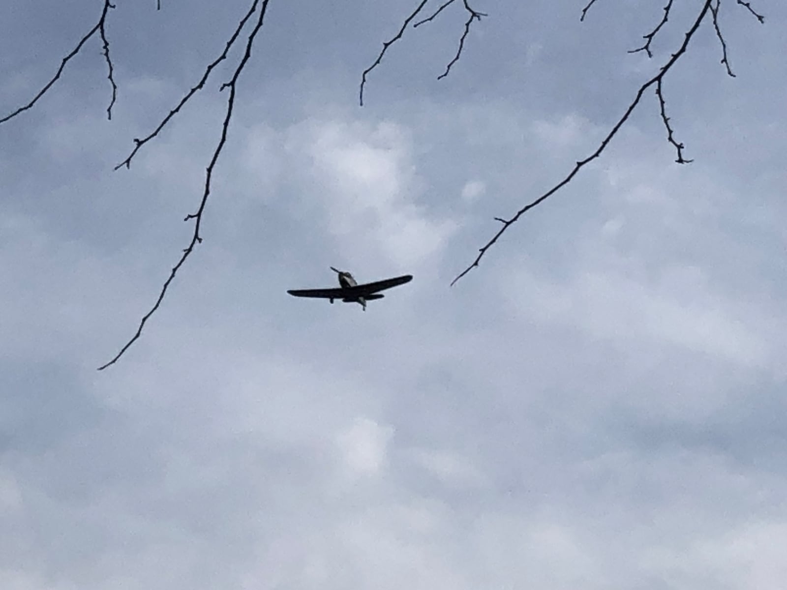 Tim Epperhart pilots an original 1943 PT-19A Cornell warplane over Richard "Dick" Gard's house in West Carrollton as part of his 100th birthday celebration. RICK McCRABB/STAFF