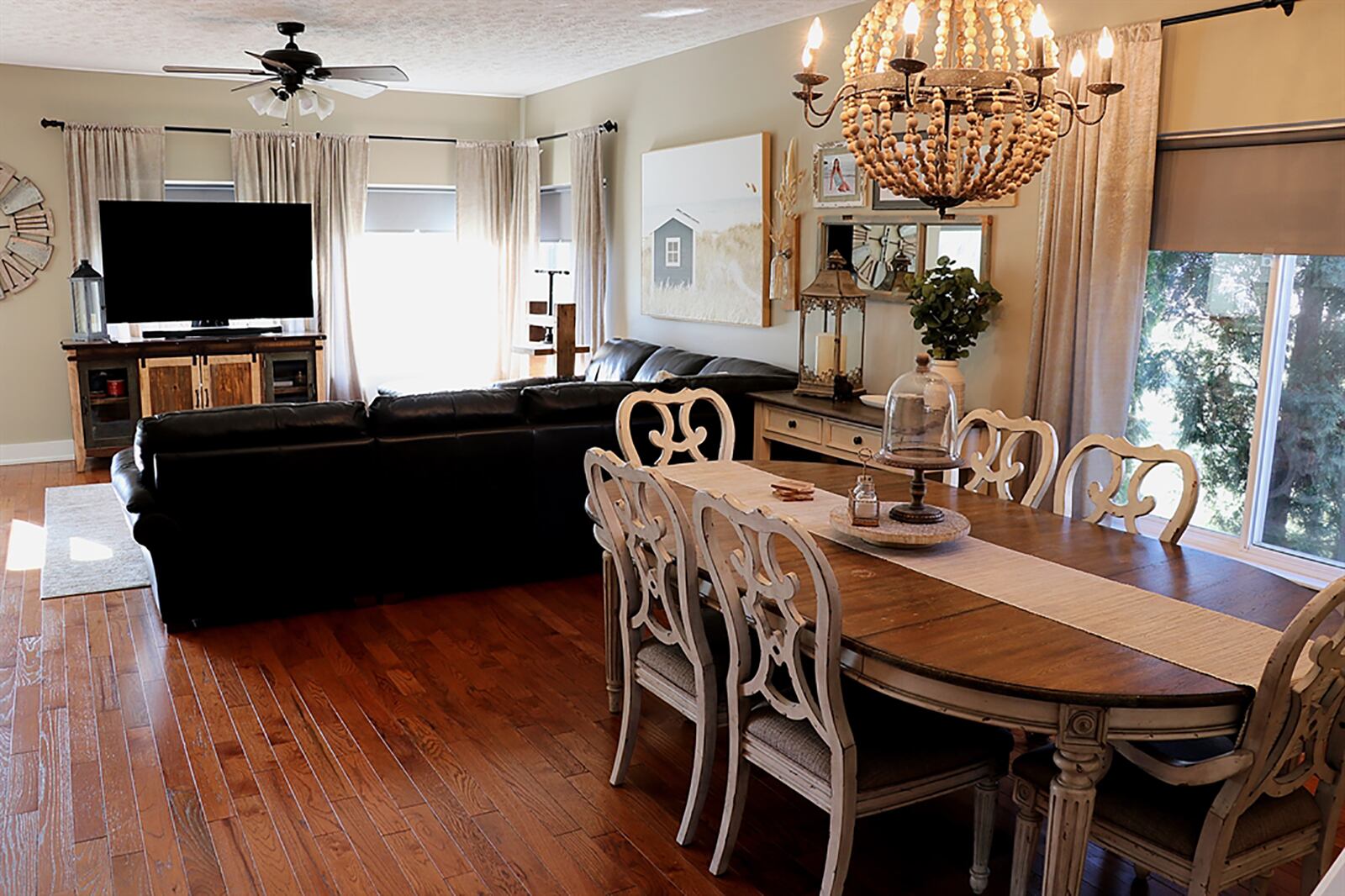 At one end of the great room is an open staircase that ascends to the second level, and on the opposite side are tall windows that look out over the back and side yards. The great room is set up as a combined living and dining room. CONTRIBUTED PHOTO BY KATHY TYLER