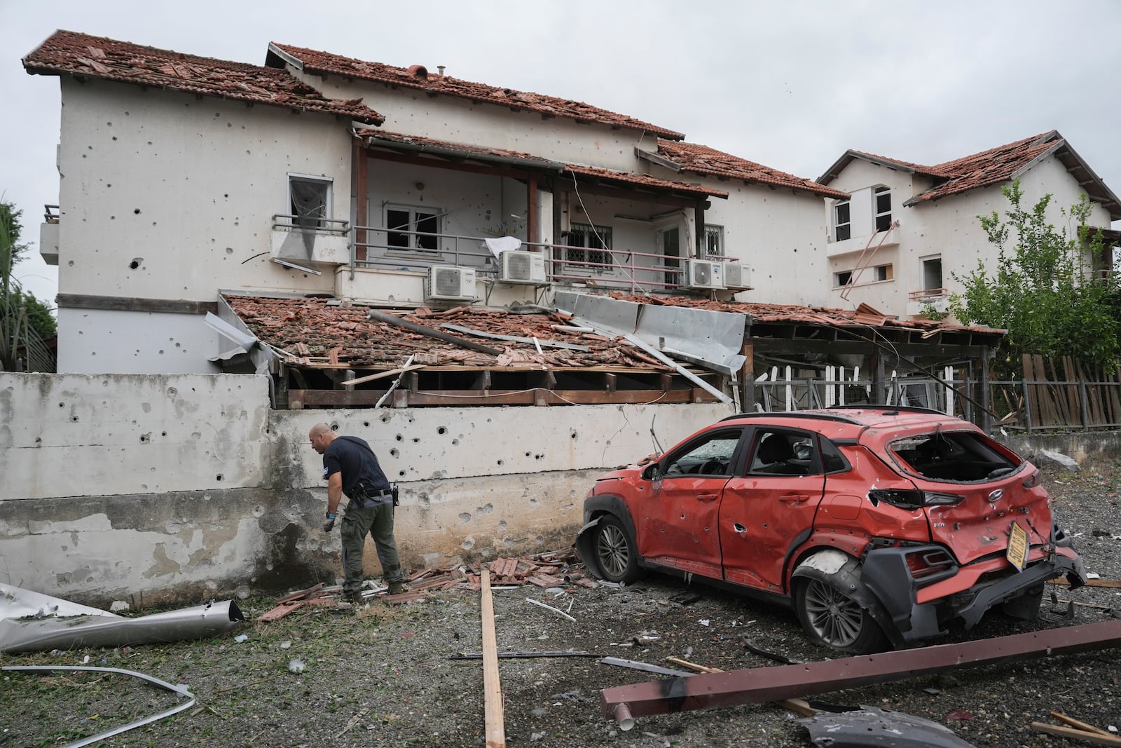 Israeli police bomb squad inspect the site after a missile fired from Lebanon hit the area in Petah Tikva, outskirts of Tel Aviv, Israel, Sunday Nov. 24, 2024. (AP Photo/Oded Balilty)