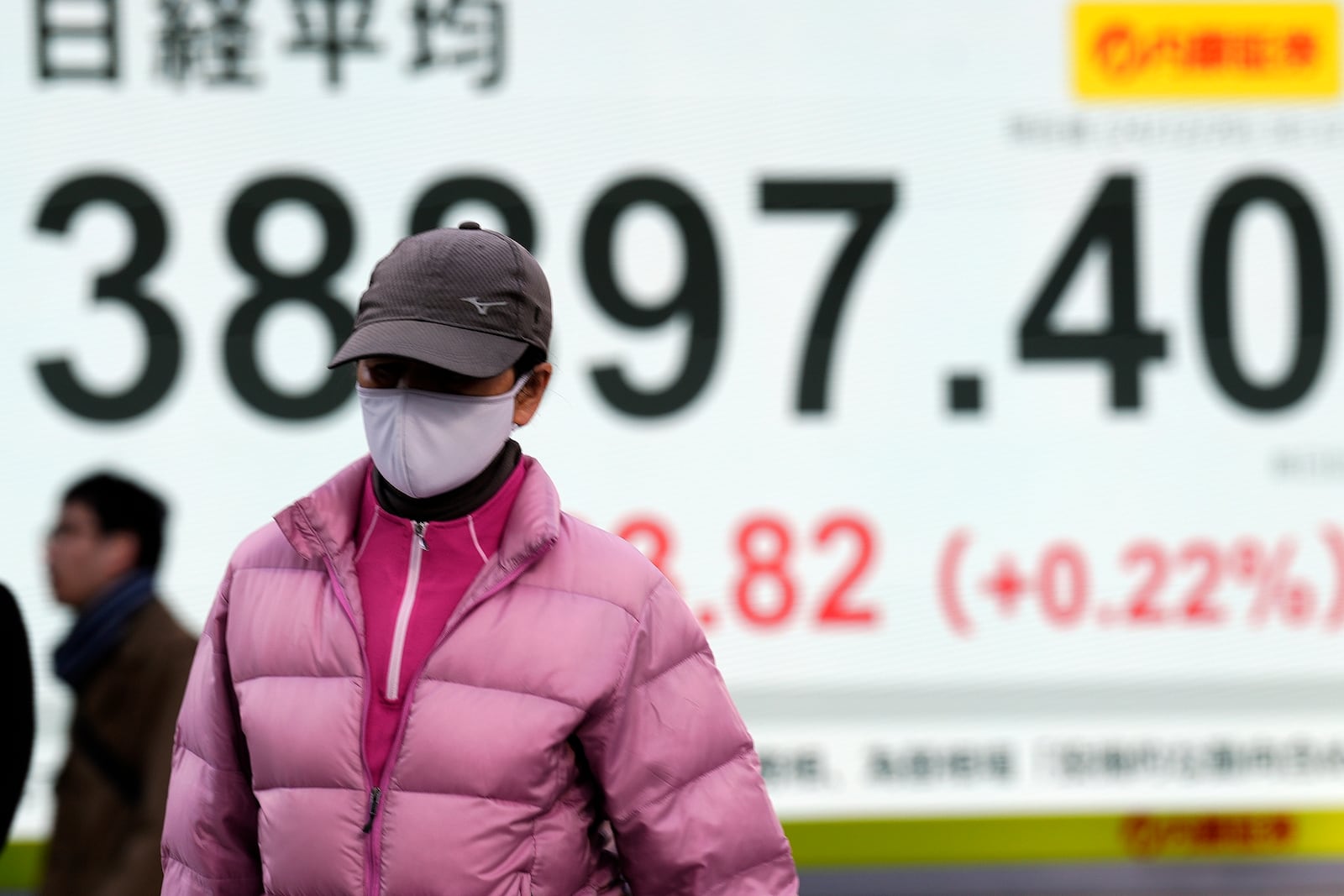 A person walks in front of an electronic stock board showing Japan's Nikkei index at a securities firm Friday, Dec. 20, 2024, in Tokyo. (AP Photo/Eugene Hoshiko)