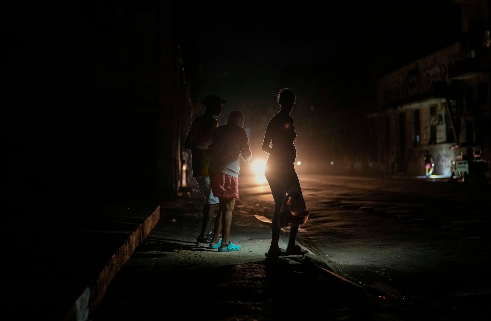 Residents walk on a street during a blackout following the failure of a major power plant in Havana, Cuba, Sunday, Oct. 20, 2024. (AP Photo/Ramon Espinosa)