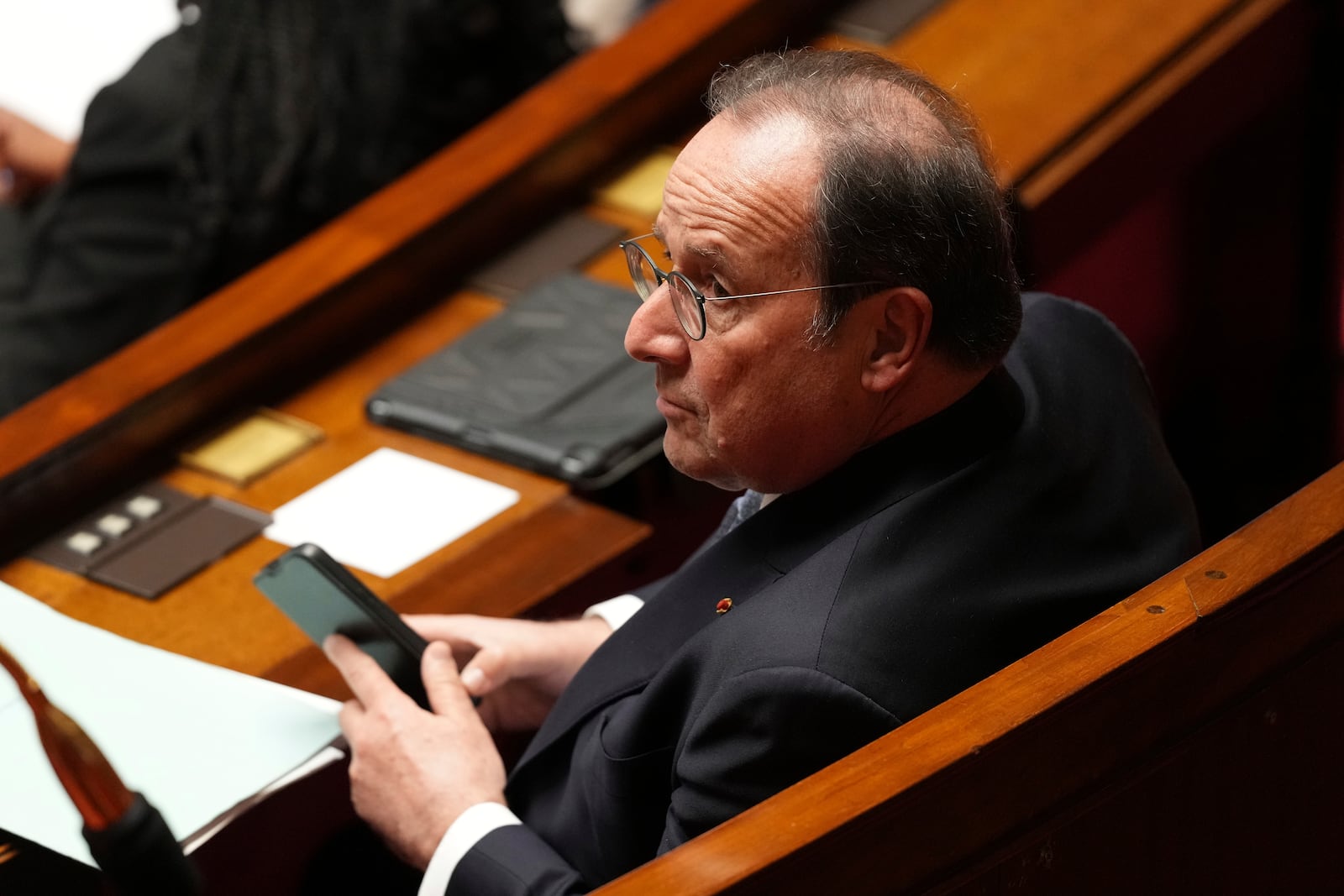 Former French President and now socialist party parliament member Francois Hollande sits at the National Assembly before French lawmakers vote on a no-confidence motion that could bring down the Prime Minister and the government for the first time since 1962, Wednesday, Dec. 4, 2024 in Paris. (AP Photo/Michel Euler)