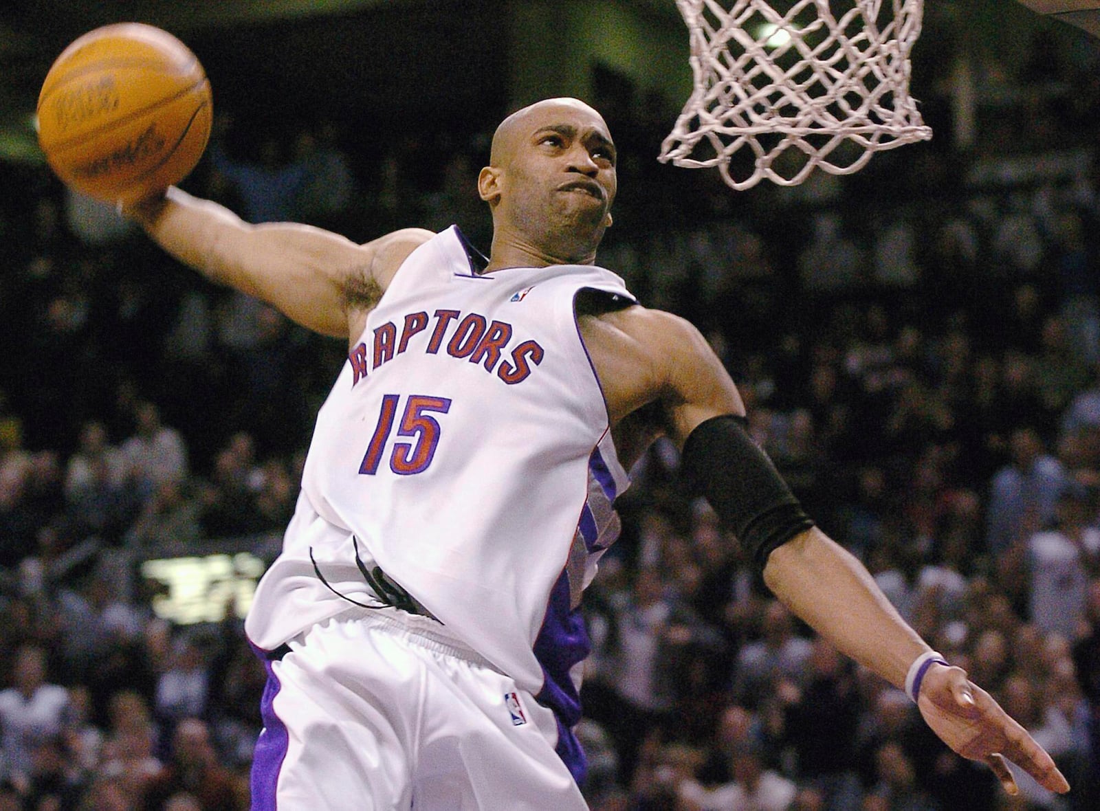 FILE - Toronto Raptors' Vince Carter dunks during the second half of an NBA basketball game against the Cleveland Cavaliers in Toronto, Wednesday, Jan. 7, 2004. (AP Photo/Aaron Harris, File)