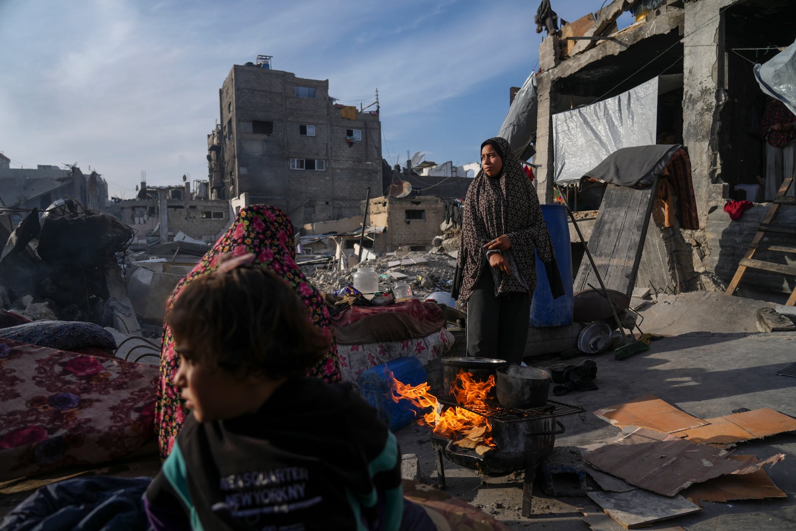 Members of Palestinian Marouf family cook outside their destroyed house by the Israeli army's air and ground offensive in Jabaliya, Gaza Strip, on Monday, March 17, 2025. (AP Photo/Jehad Alshrafi)