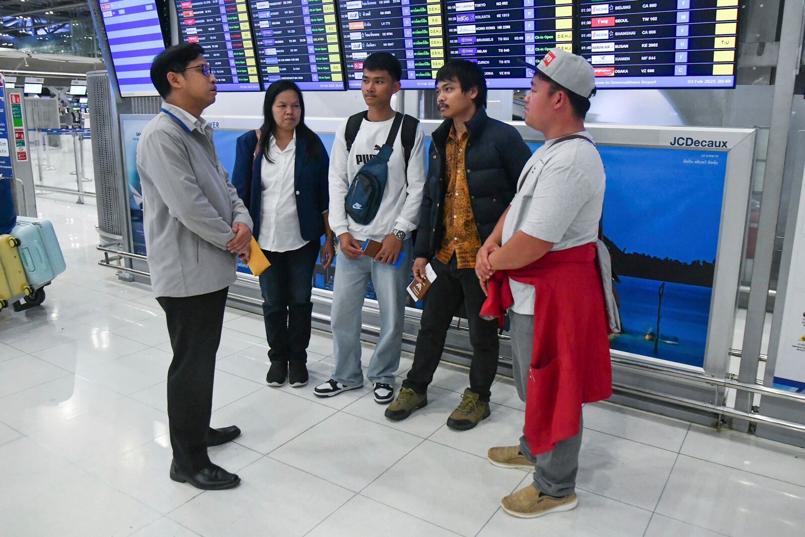 In this photo provided by the Thai Foreign Ministry, an official, left, from the Department of Consular Affairs, talks to family members of released Thai hostages freed from Hamas, before they travel to Tel Aviv, Israel, from the Suvarnabhumi International Airport in Samut Prakarn Province, Thailand, Monday, Feb. 3, 2025. (Thai Foreign Ministry via AP)