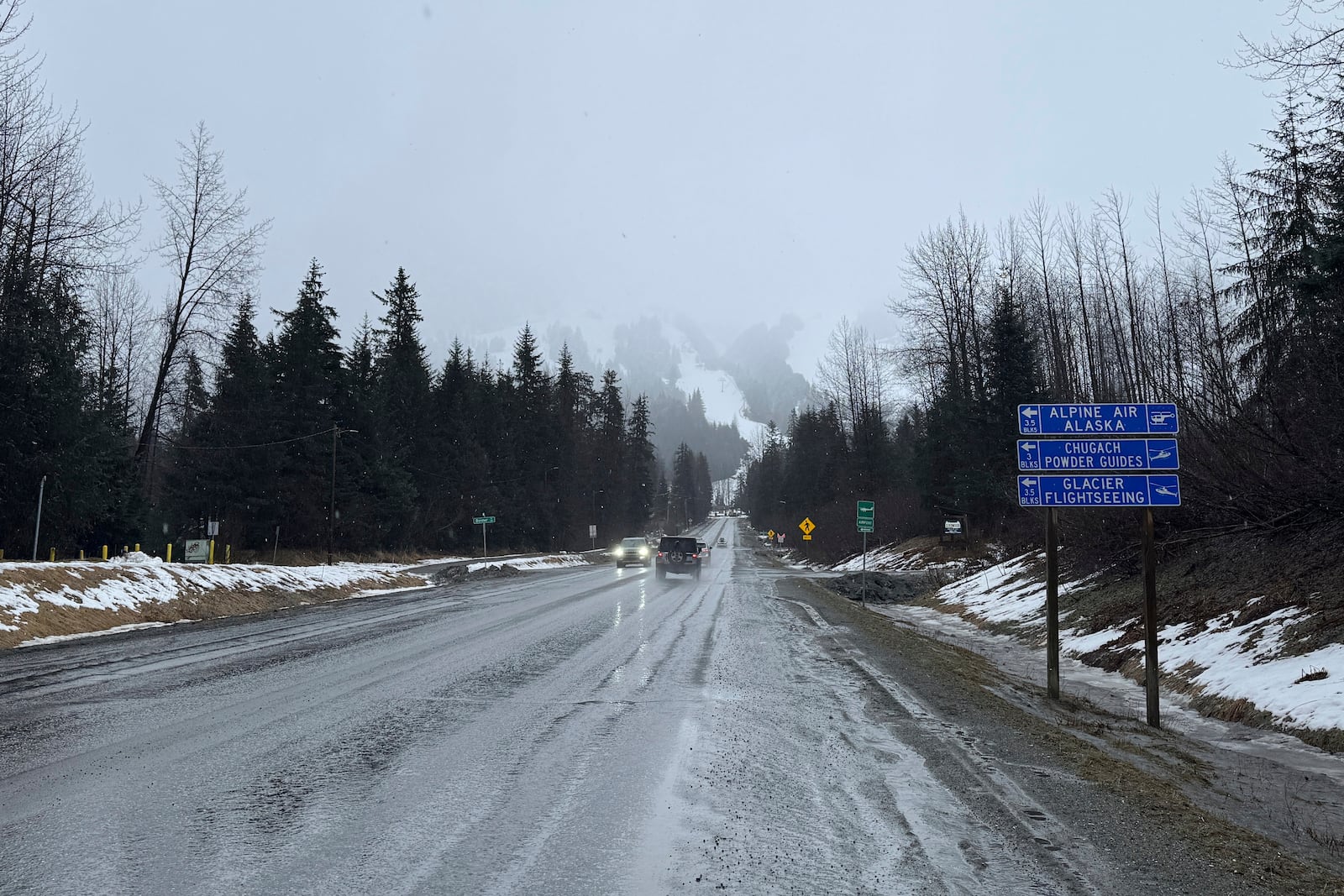 A sign on Alyeska Highway points to winter tourism businesses in Girdwood, Alaska, on Wednesday, March 1, 2025. (AP Photo/Mark Thiessen)