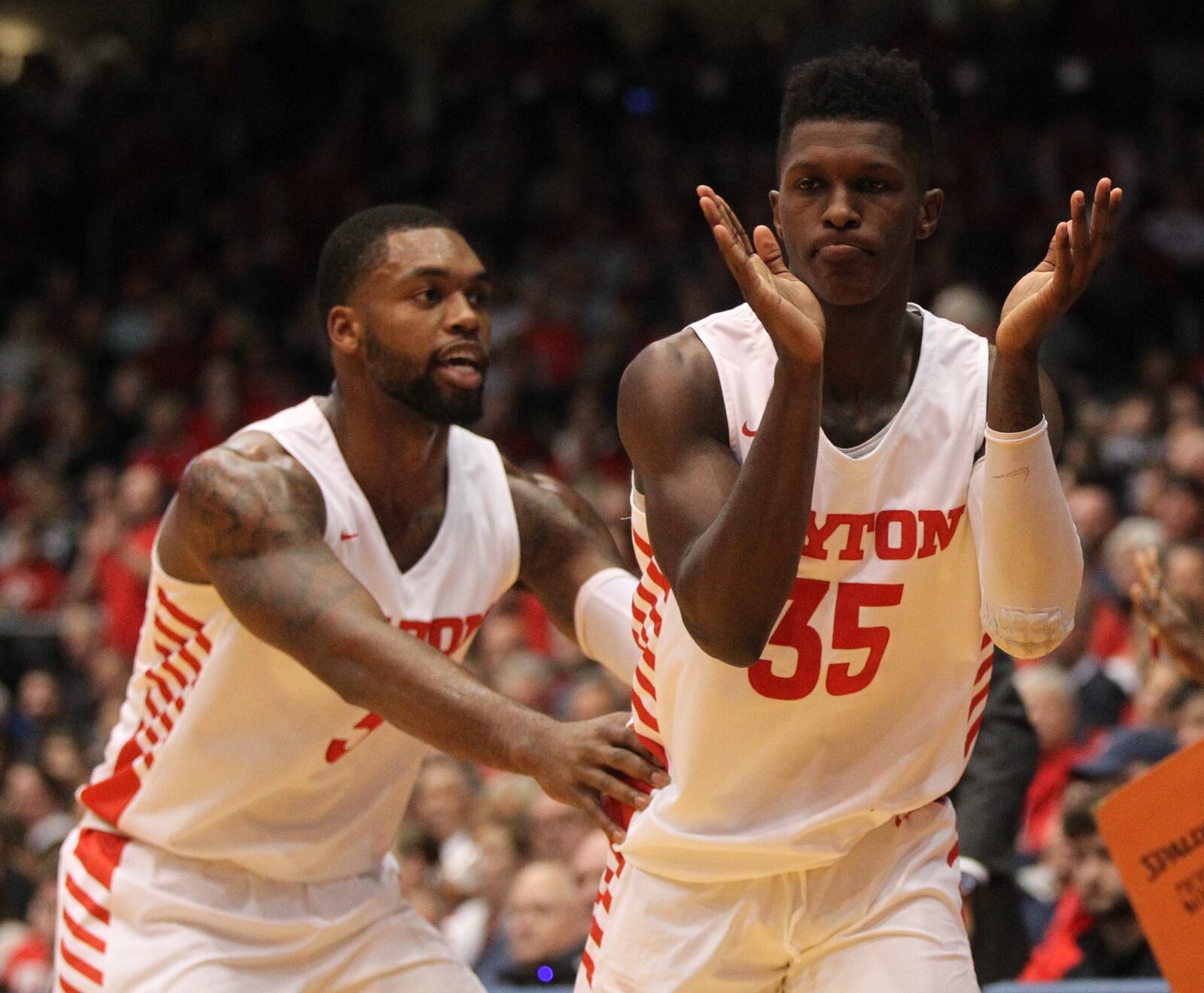 Dayton’s Dwayne Cohill claps as Trey Landers congratulates him after a defensive stop against Coppin State on Saturday, Nov. 10, 2018, at UD Arena.