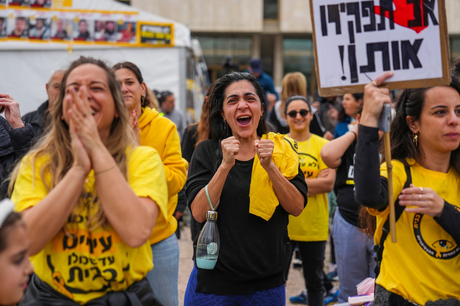 Relatives and friends of Israeli people killed and abducted by Hamas and taken into Gaza, react as they follow the news of the hostages' release, in Tel Aviv, Israel, Saturday, Jan. 25, 2025. (AP Photo/Ariel Schalit)