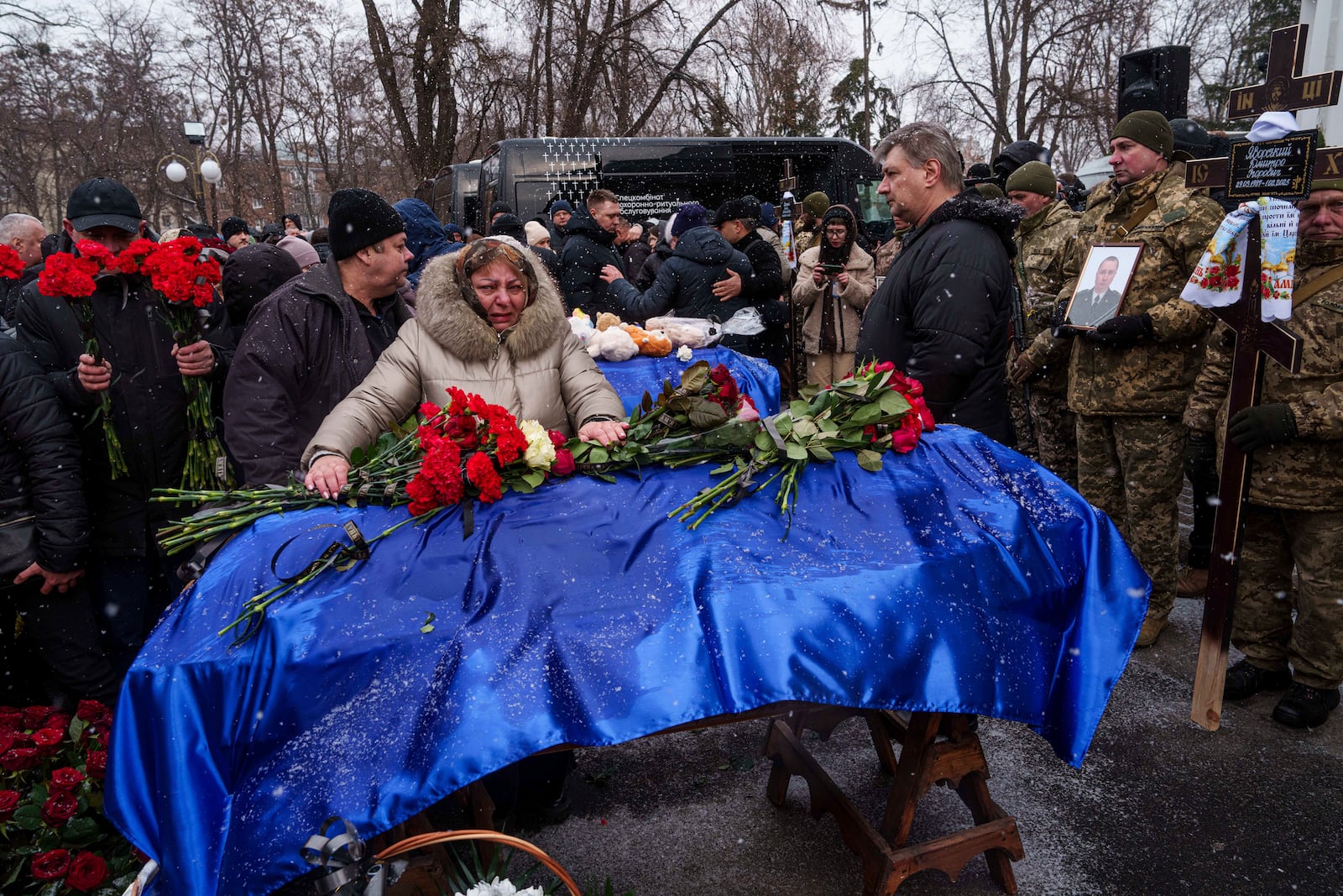 Relatives say goodbye to Dmytro Yavorskyi, 37, Sofia Yavorska, 9, Olena Yavorska 38, who were killed on Feb. 1 by a Russian strike on residential building during a funeral ceremony in Poltava, Ukraine, Wednesday, Feb. 5, 2025. (AP Photo/Evgeniy Maloletka)