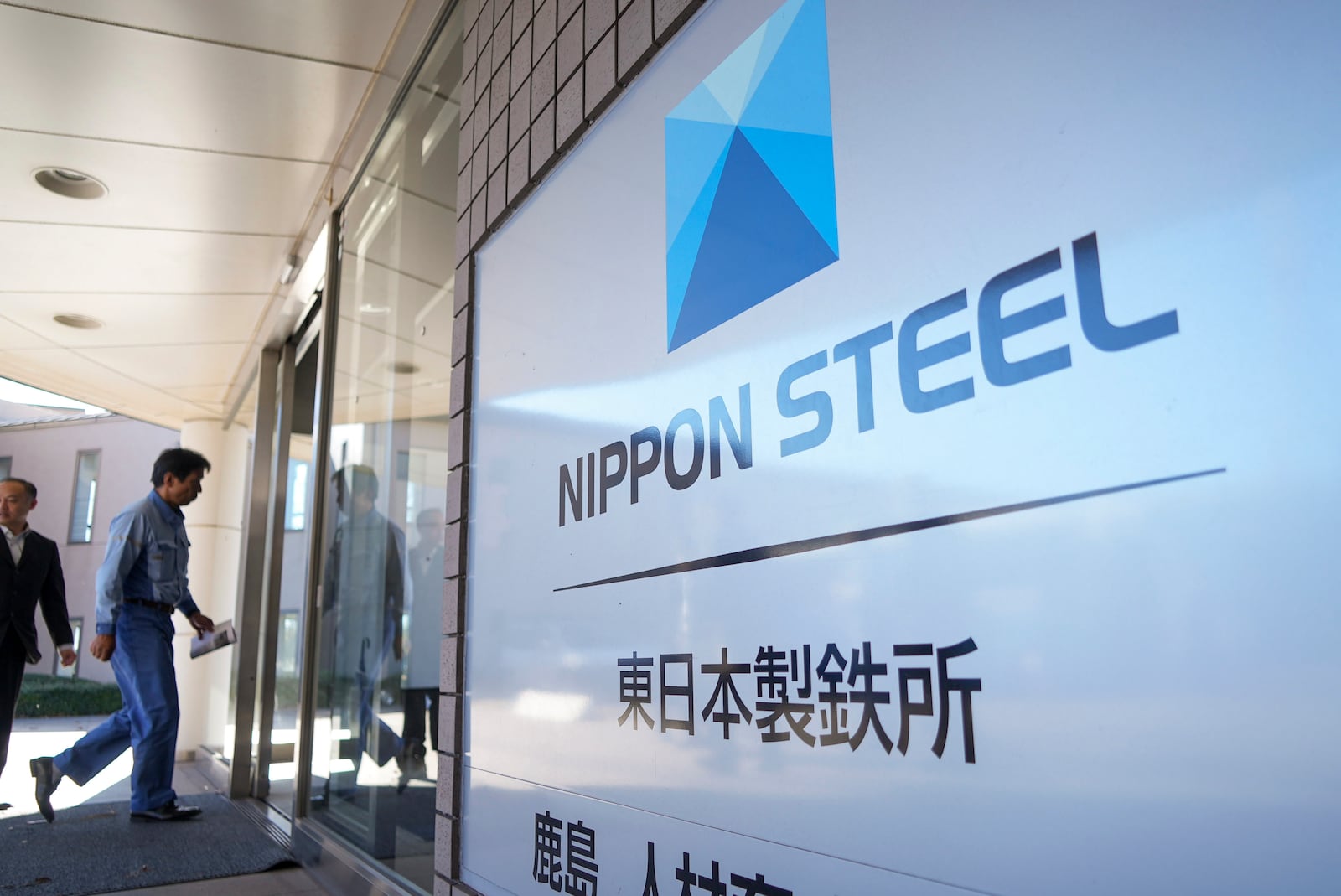 FILE - A staff enters doorway next to Nippon Steel logo at the company's Kashima Plant in Kashima, Japan on Friday, Dec. 6, 2024. (AP Photo/Ayaka McGill, File)