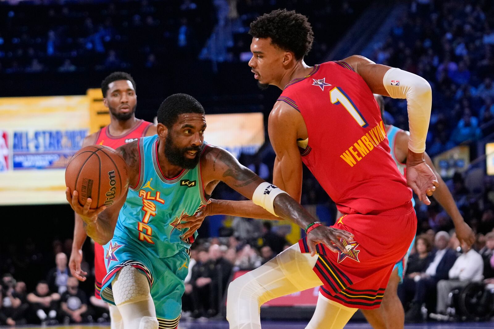 Dallas Mavericks guard Kyrie Irving, left, dribbles past San Antonio Spurs center Victor Wembanyama during the NBA All-Star basketball game Sunday, Feb. 16, 2025, in San Francisco. (AP Photo/Godofredo A. Vásquez)