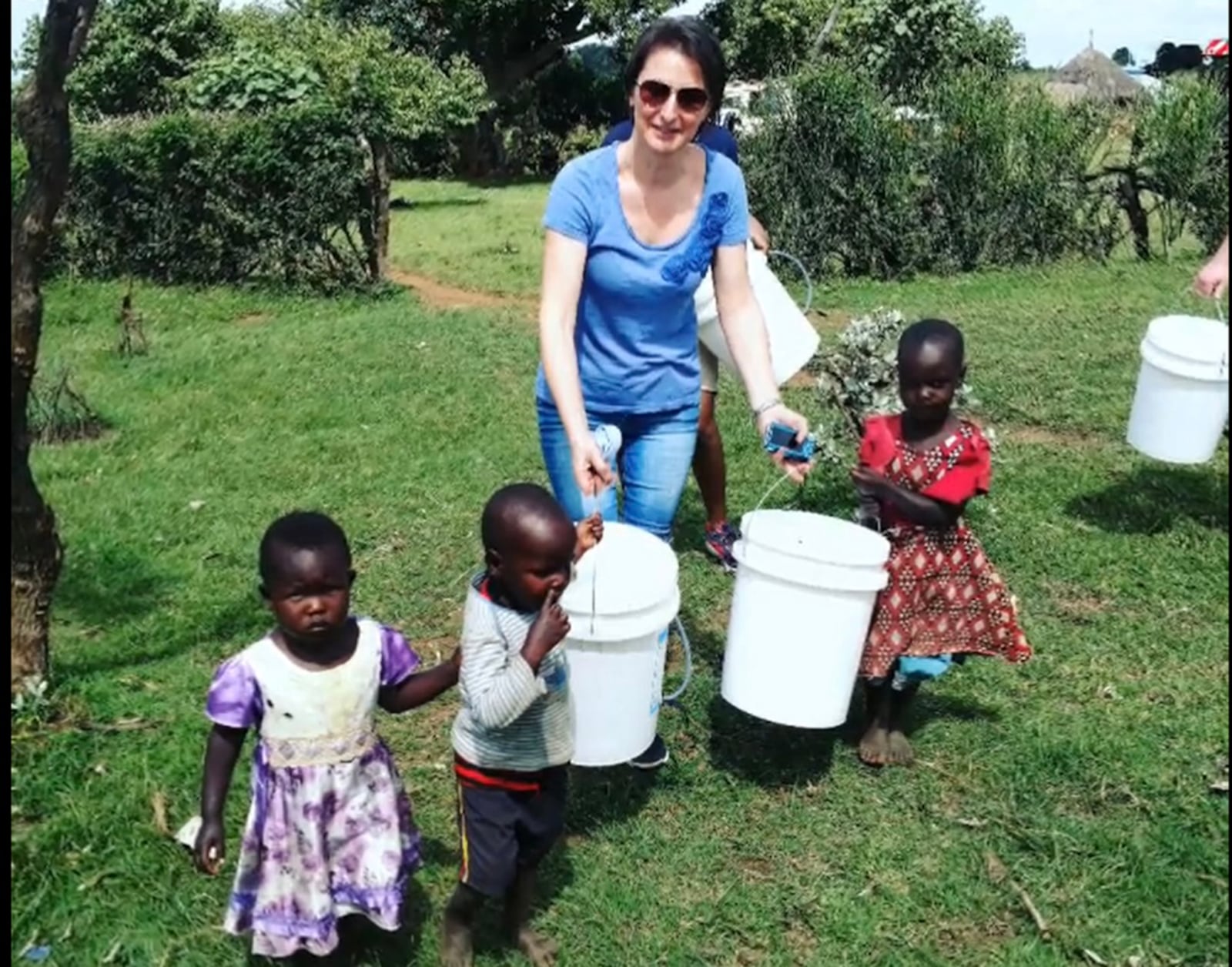 Narcisa Mikov of Miamisburg is the executive director of RipplAffect, a local nonprofit dedicated to ensuring all people across the globe have access to clean drinking water. She is shown in Kenya carrying water with local children. CONTRIBUTED