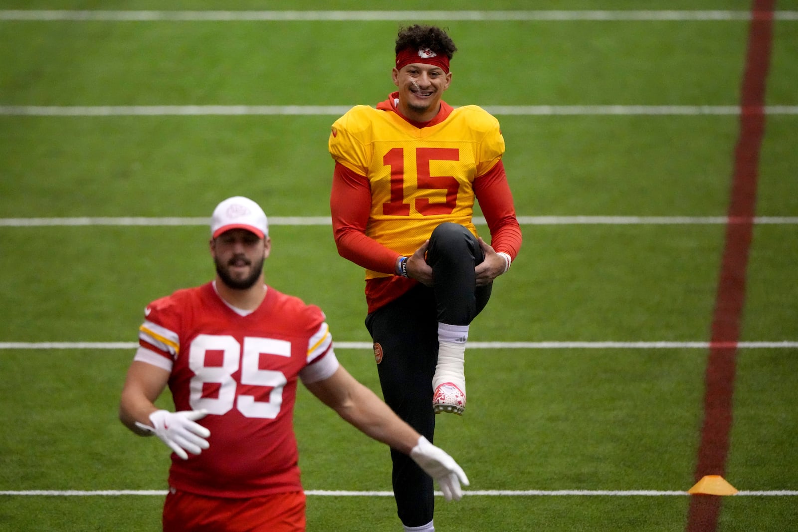 Kansas City Chiefs quarterback Patrick Mahomes (15) and tight end Anthony Firkser (85) stretch during the NFL football team's practice Wednesday, Jan. 22, 2025, in Kansas City, Mo. (AP Photo/Charlie Riedel)