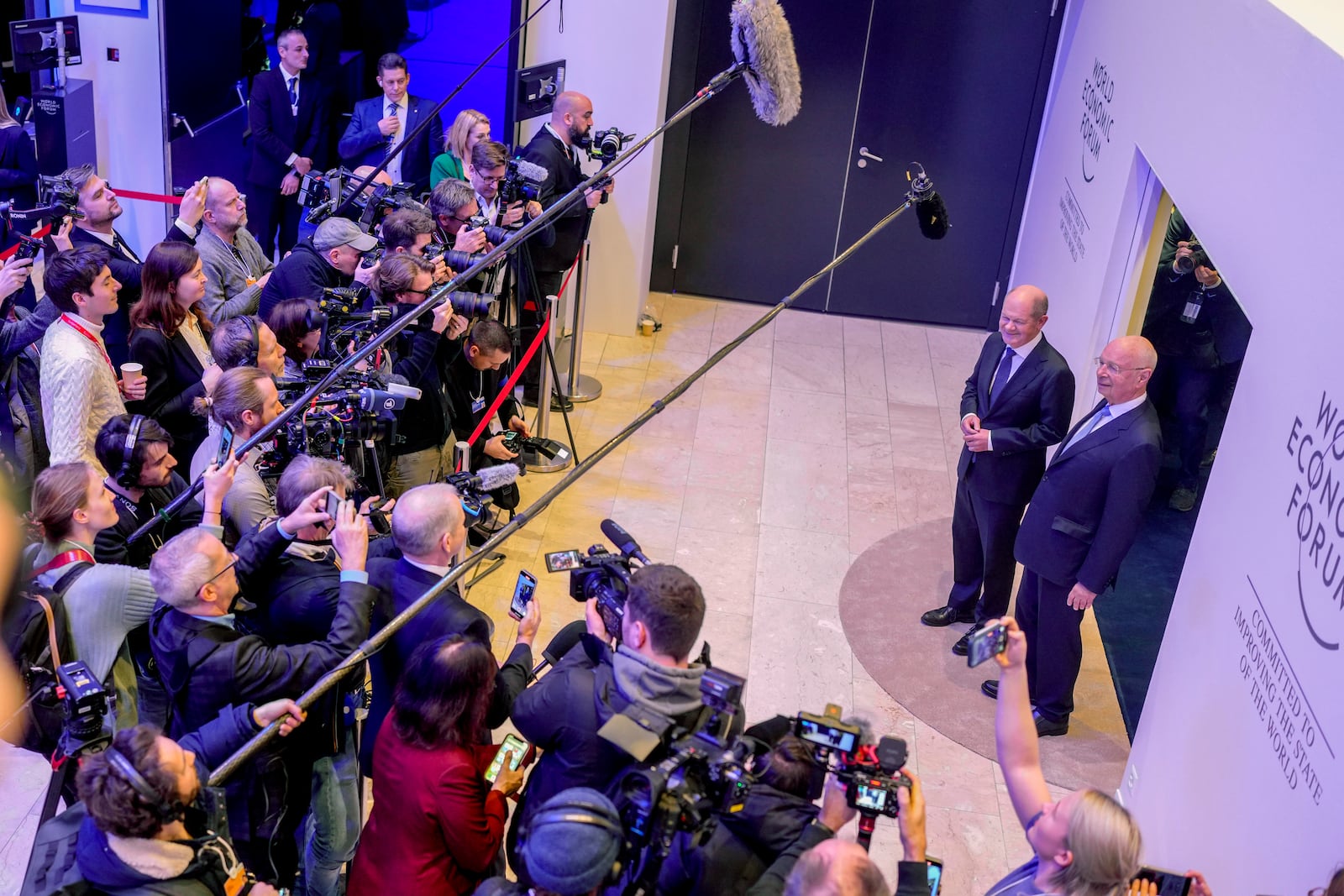 German Chancellor Olaf Scholz, left, and WEF founder Klaus Schwab meet the media at the Annual Meeting of World Economic Forum in Davos, Switzerland, Tuesday, Jan. 21, 2025. (AP Photo/Markus Schreiber)