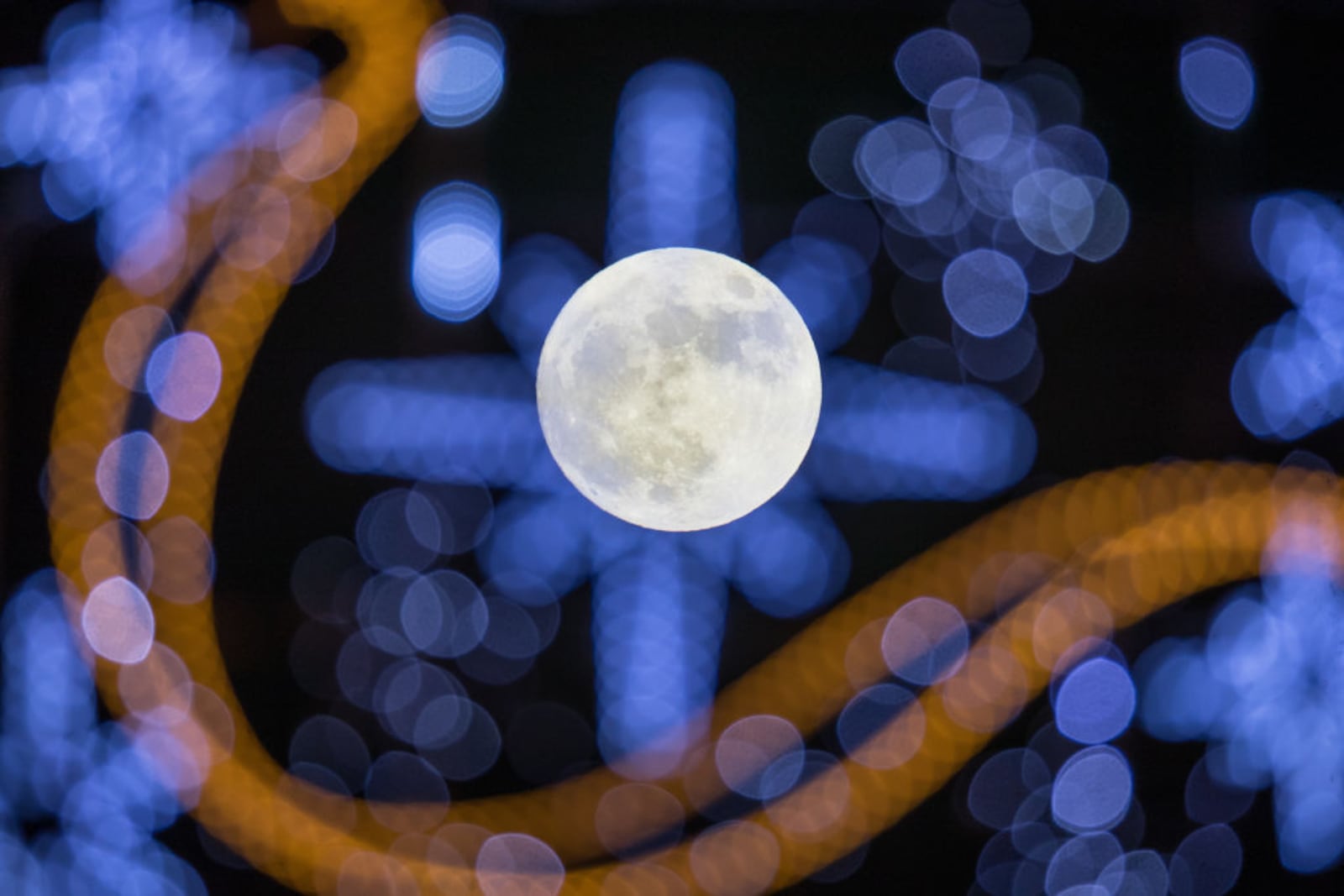 WELLS, ENGLAND - JANUARY 01:  The first full moon of 2018 rises behind festive seasonal lights on display in the High Street in Wells on January 1, 2018 in Somerset, England. Tonight's full moon, which is known by Native American tribes as the "Wolf Moon", is also a supermoon which means it coincides with the Moon's closest approach to Earth, known as the perigee. Tonights Wolf Moon is the first of two full moons in January. The second will take place on the night of January 31 and in some areas of the world this will also happen at the same time as a total lunar eclipse.  (Photo by Matt Cardy/Getty Images)