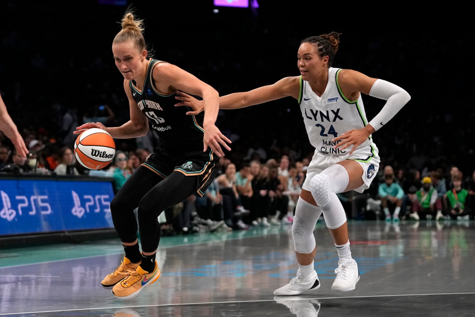 New York Liberty's Leonie Fiebich, left, dribbles against Minnesota Lynx's Napheesa Collier, right, during the first half in Game 2 of a WNBA basketball final playoff series, Sunday, Oct. 13, 2024, in New York. (AP Photo/Pamela Smith)