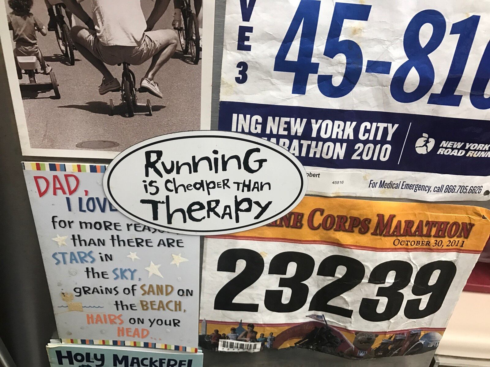 Refrigerator in Bob Welbaum s kitchen in Centerville covered with his race bibs from events around world. In middle is sticker saying Running is cheaper than therapy. Bob who runs for mental health says that is true. Tom Archdeacon/CONTRIBUTED