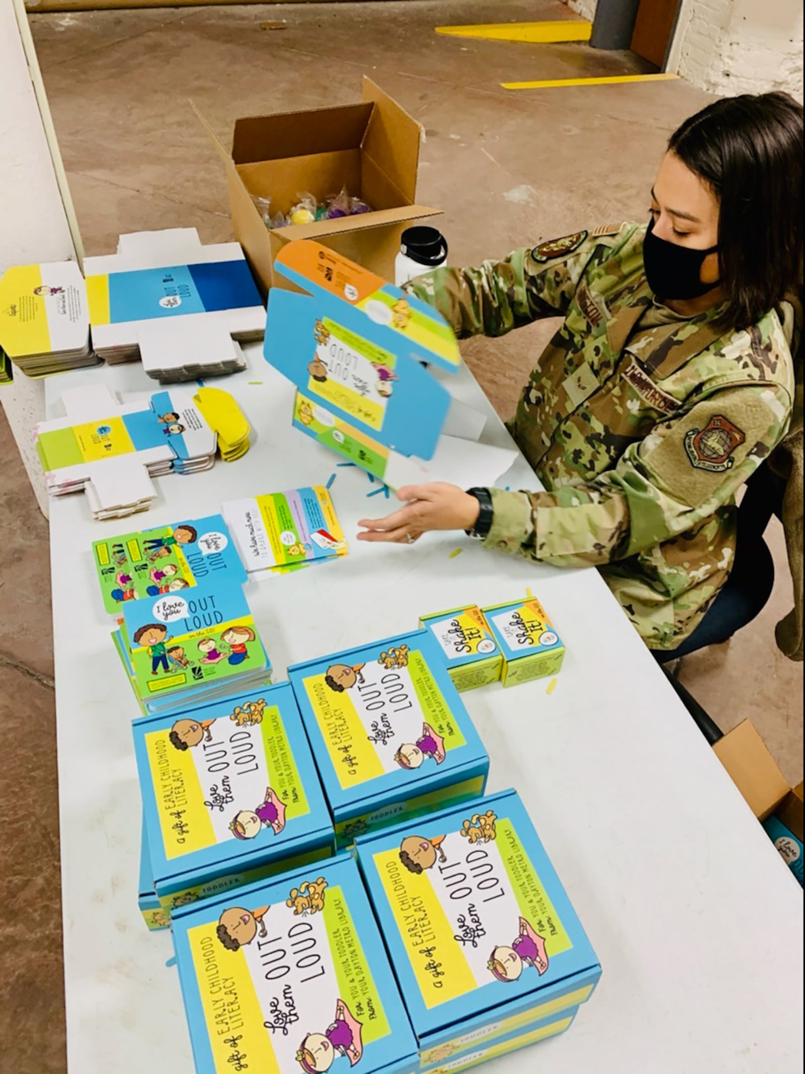 Airman 1st Class Miranda Hutton of Wright-Patterson Air Force Base’s National Air and Space Intelligence Center puts together “Love Them Out Loud” kits during the Dec. 18 volunteer event benefiting the Dayton Metro Library and early childhood literacy. CONTRIBUTED PHOTO