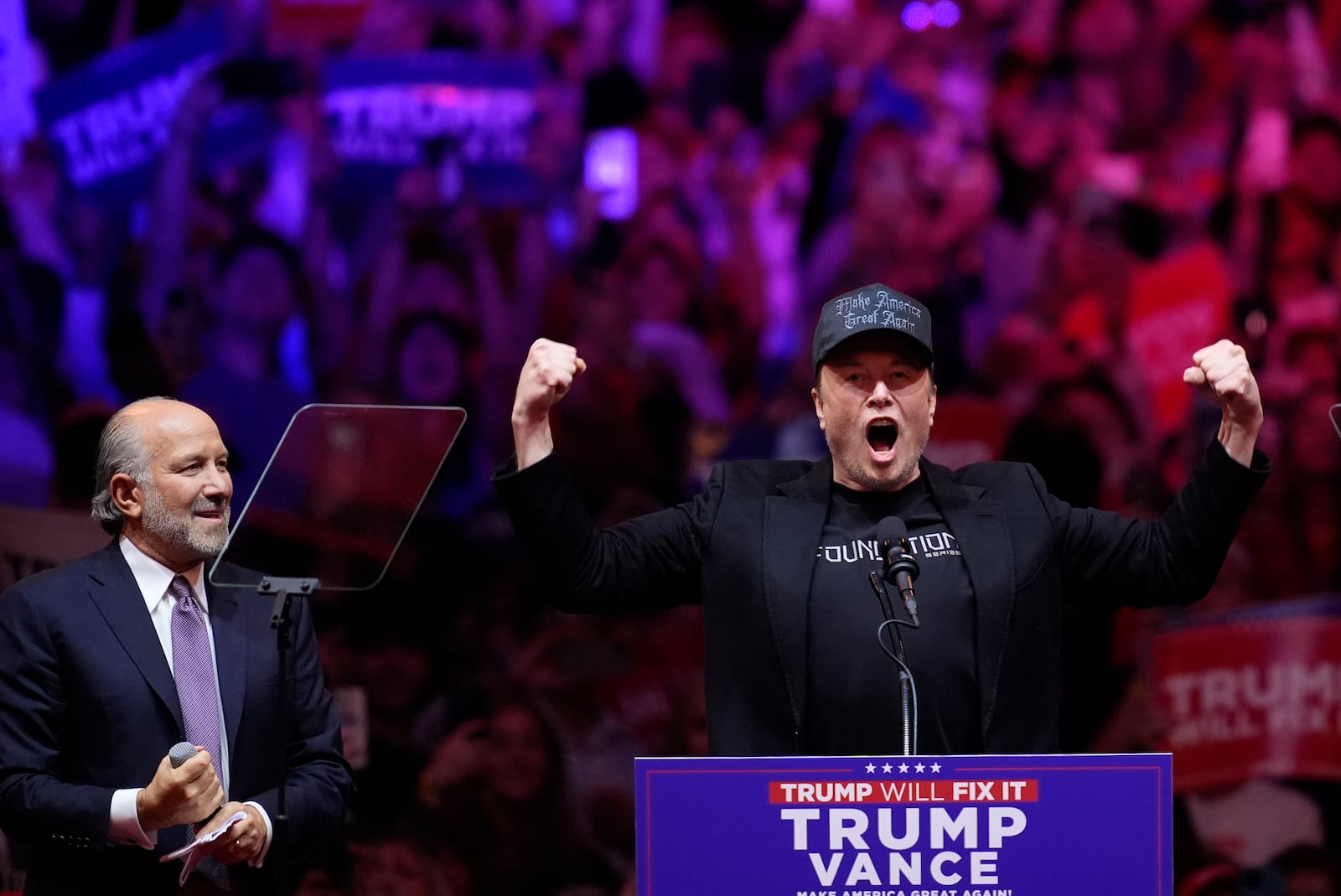 Elon Musk speaks as Howard Lutnick listens before Republican presidential nominee former President Donald Trump at a campaign rally at Madison Square Garden, Sunday, Oct. 27, 2024, in New York. (AP Photo/Evan Vucci)