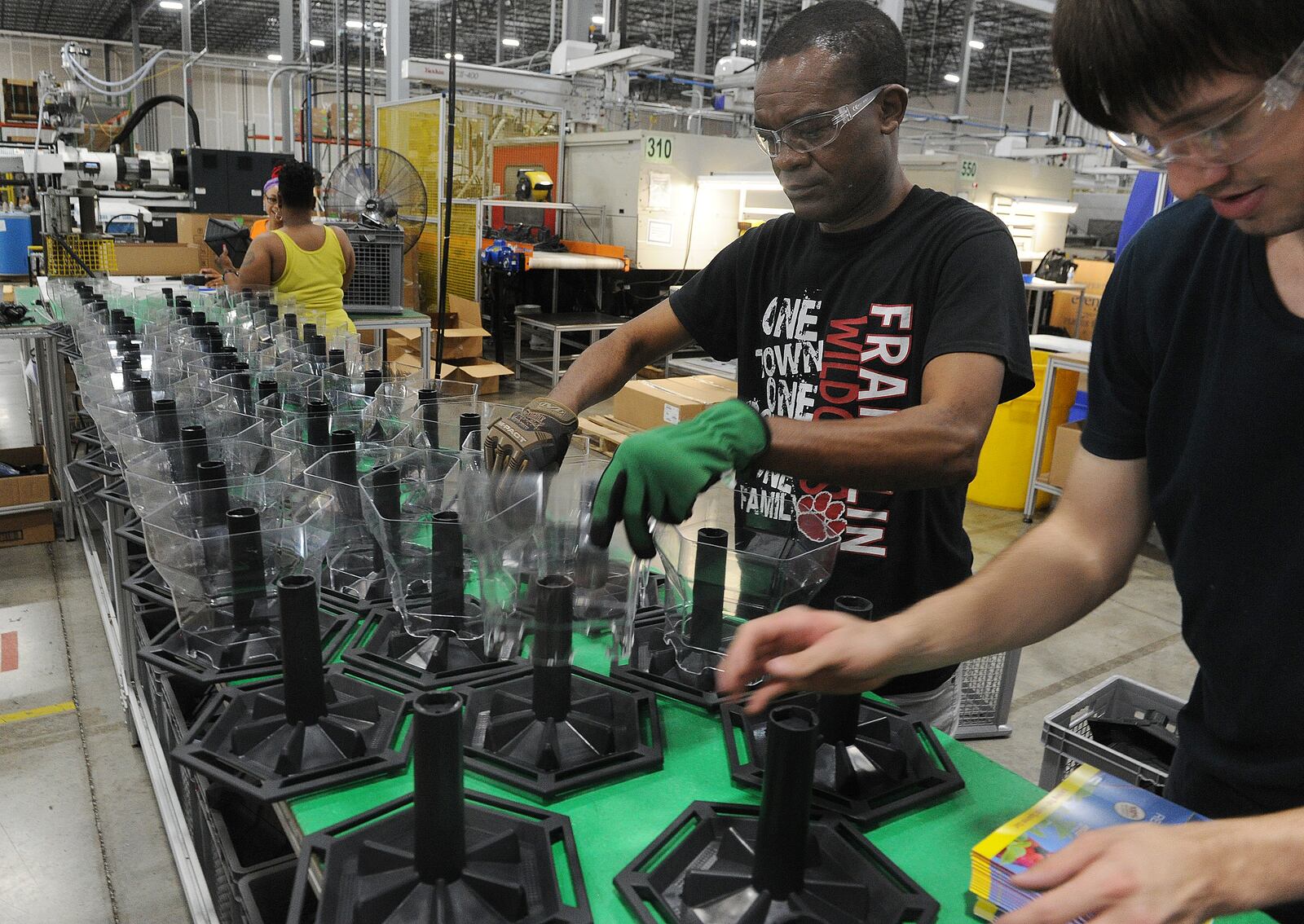 Employees of Innovative Plastic Molders assemble birdfeeders. The company manufactures all the plastic parts in house. MARSHALL GORBY\STAFF