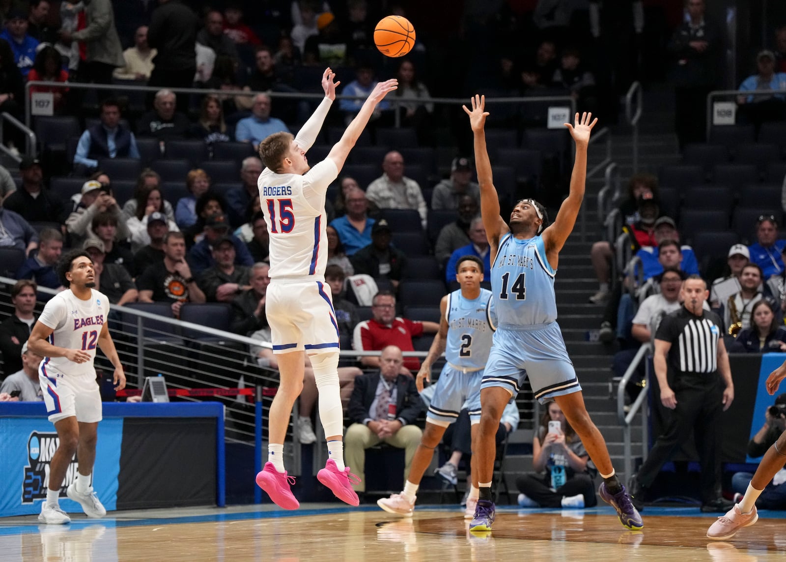 American University forward Matt Rogers (15) shoots against Mount St. Mary's forward Jedy Cordilia (14) during the first half of a First Four college basketball game in the NCAA Tournament, Wednesday, March 19, 2025, in Dayton, Ohio. (AP Photo/Jeff Dean)