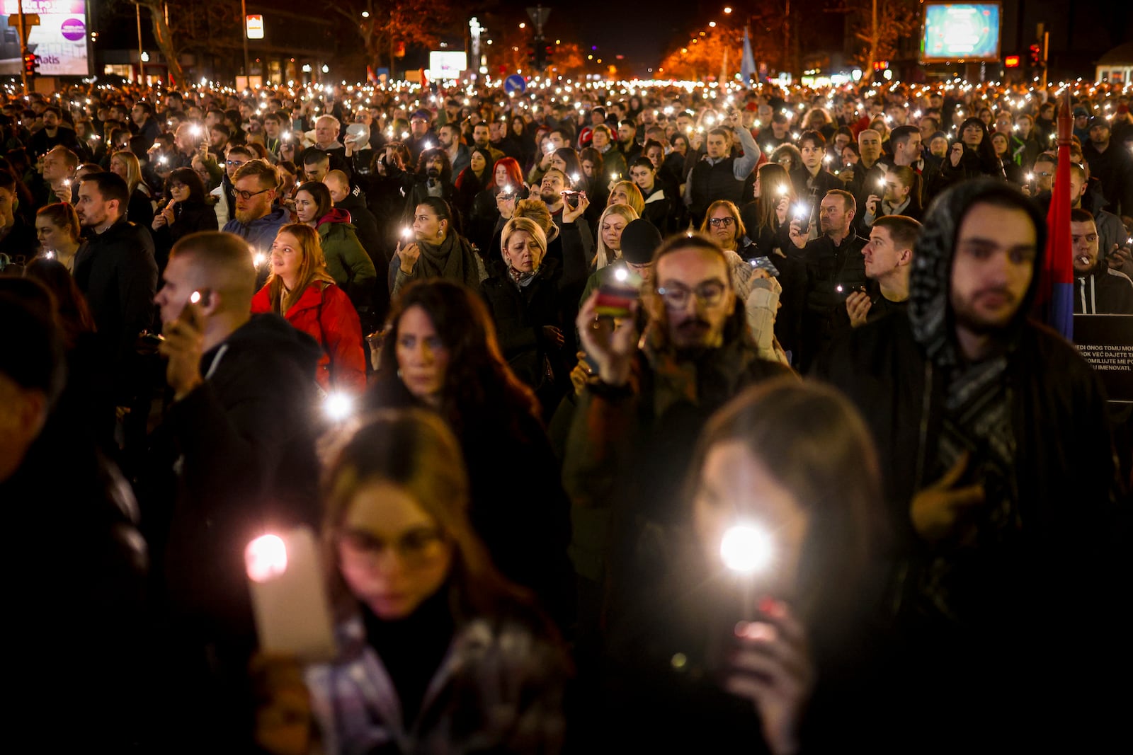 People hold up their mobile phone lights during a protest over the collapse of a concrete canopy that killed 15 people more than two months ago, in Novi Sad, Serbia, Friday, Jan. 31, 2025. (AP Photo/Armin Durgut)