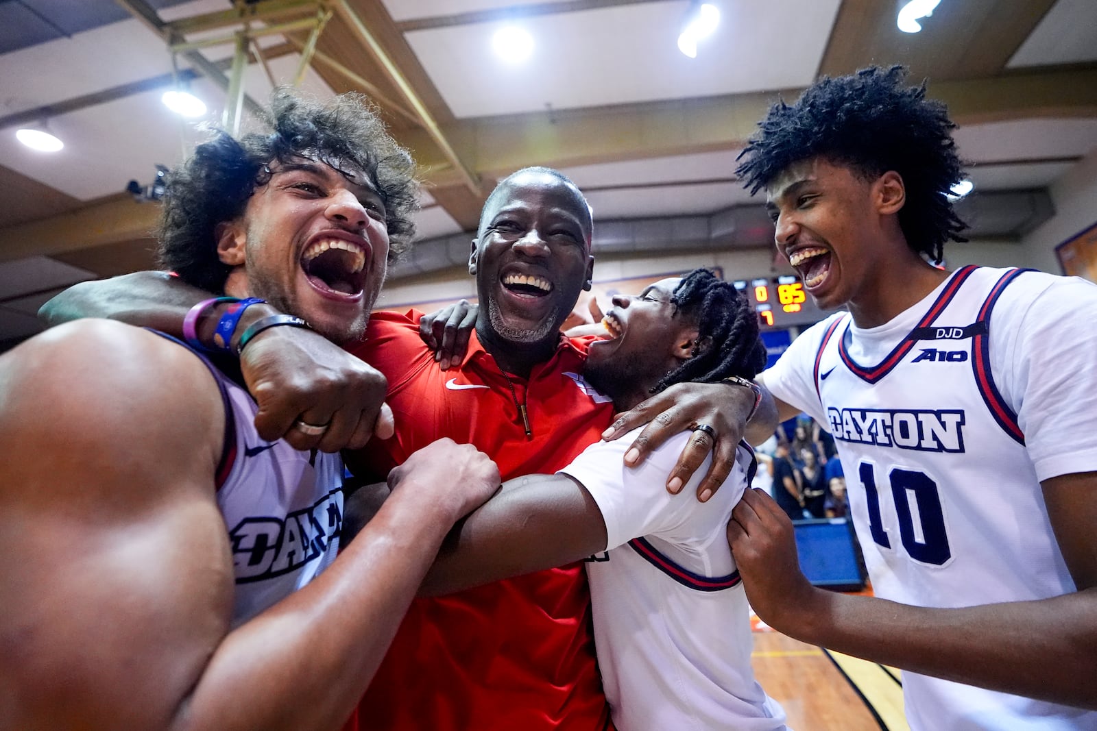 From left, Dayton forward Nate Santos, Dayton head coach Anthony Grant, guard Malachi Smith and guard Hamad Mousa (10) celebrate an 85-67 win over UConn in an NCAA college basketball game at the Maui Invitational Wednesday, Nov. 27, 2024, in Lahaina, Hawaii. (AP Photo/Lindsey Wasson)