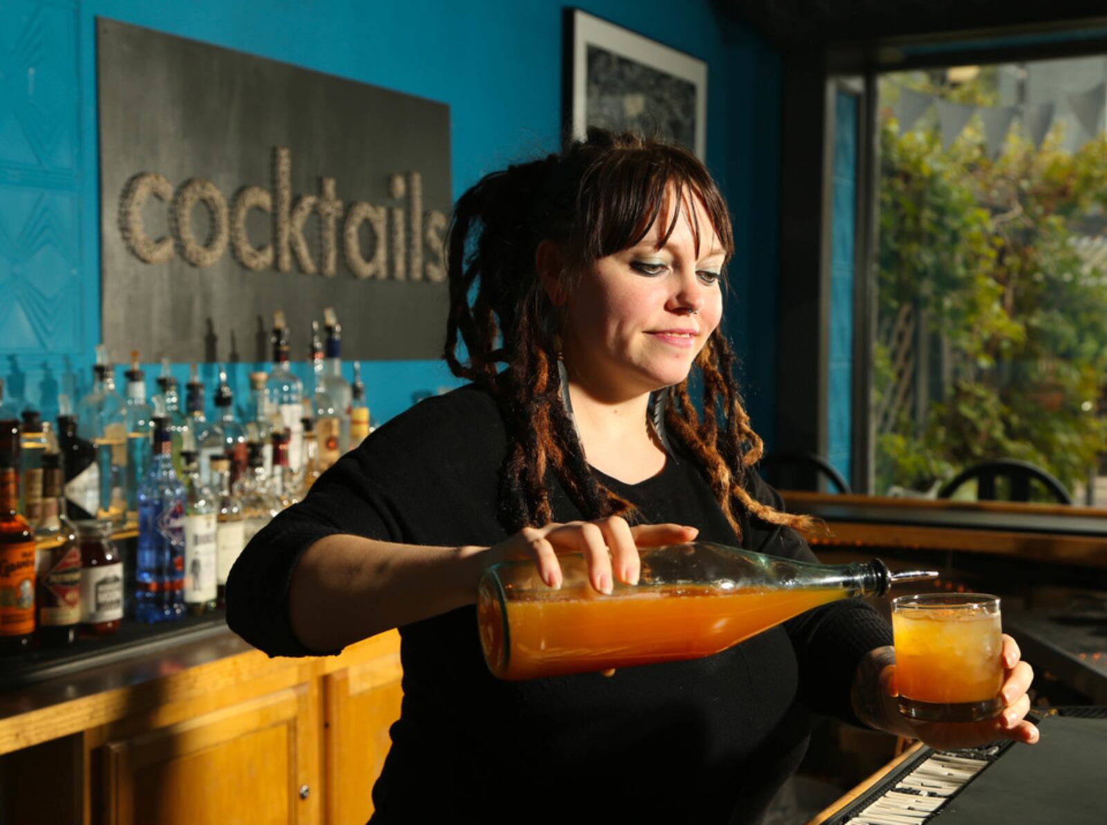 Amber Brady, Bar Manager at Lily's Bistro, pours apple cider to finish their seasonal cocktail, Harvest Moon. JIM WITMER/ STAFF