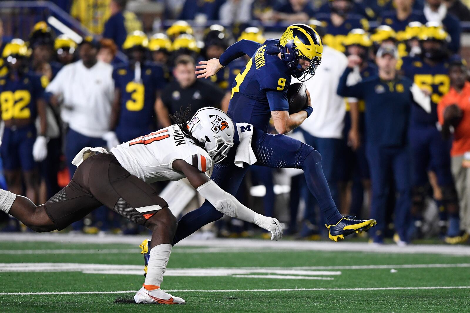 Michigan quarterback J.J. McCarthy (9) hurdles away from Bowling Green linebacker Demetrius Hardamon in the second half of an NCAA college football game, Saturday, Sept. 16, 2023, in Ann Arbor, Mich. (AP Photo/Jose Juarez)