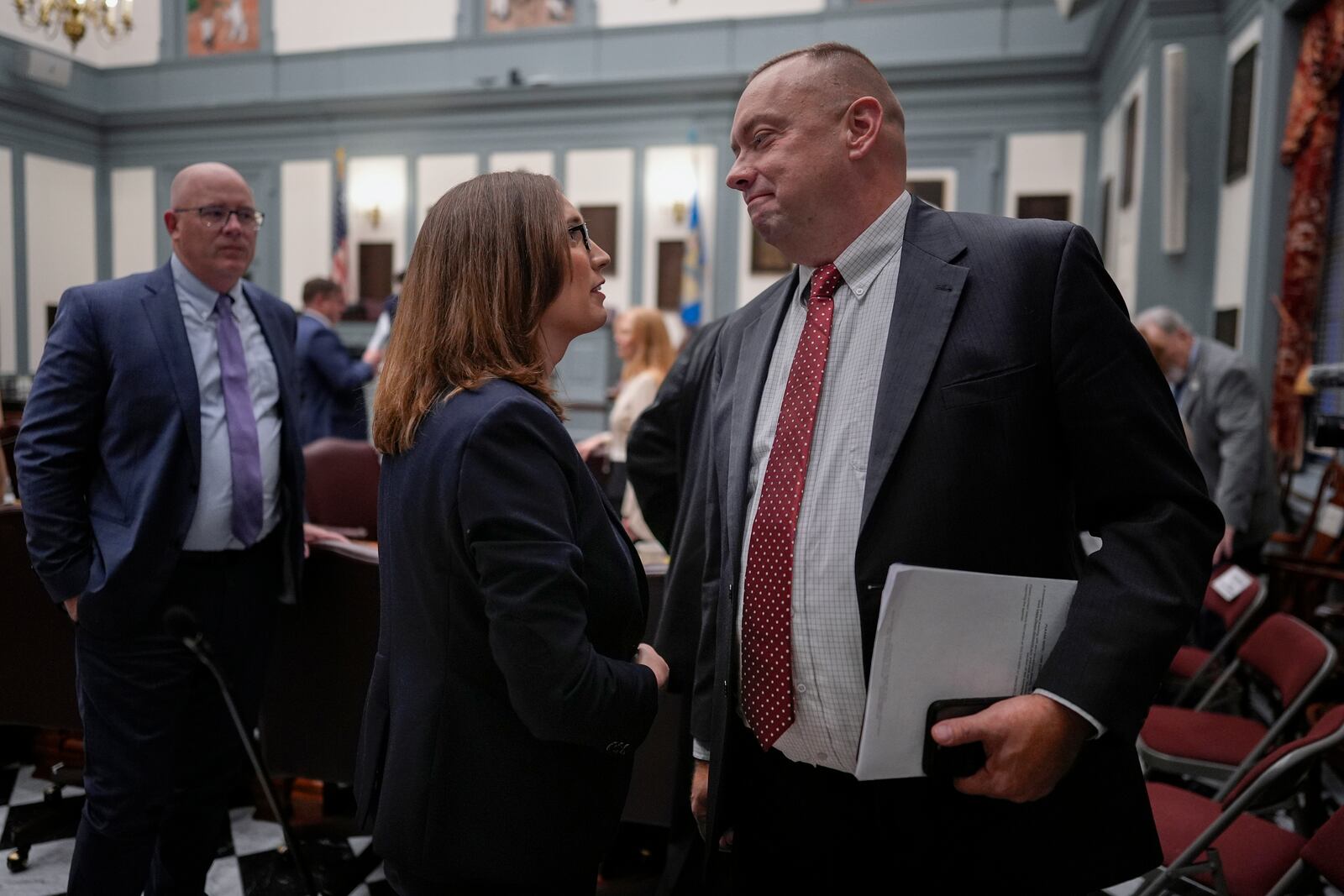 U.S.-Rep.-elect Sarah McBride, D-Del., center, talks with Delaware Senate Republican Minority Whip Brian Pettyjohn from the 19th district on the Senate floor on McBride's last day as a Delaware state senator at the Delaware Legislative Hall in Dover, Del., Monday, Dec. 16, 2024. (AP Photo/Carolyn Kaster)